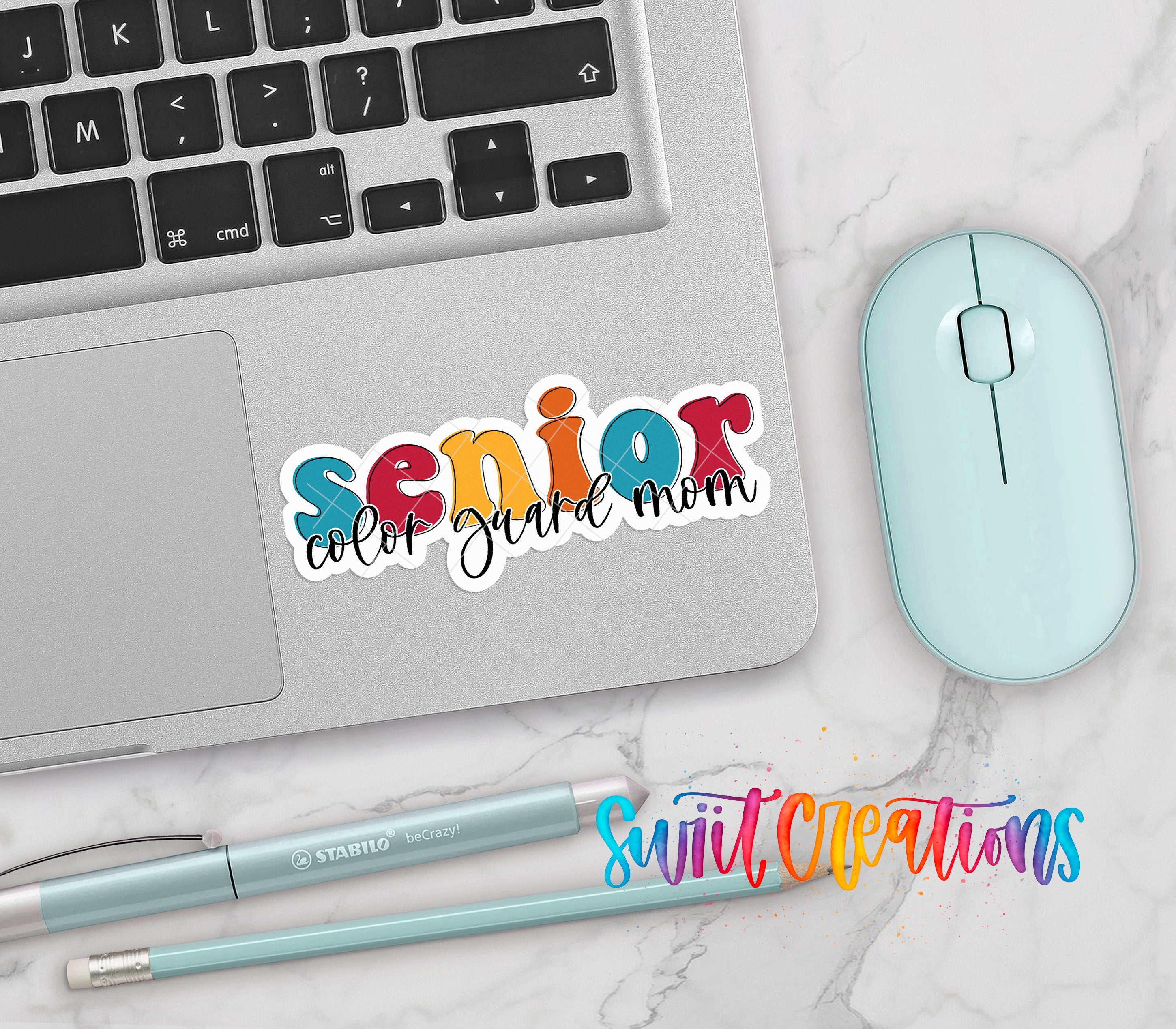 a laptop, a mouse, and various office supplies such as pens and pencils, all arranged on a marble surface.