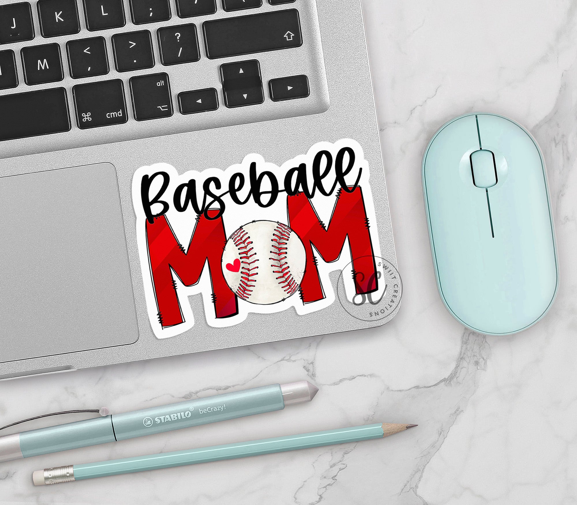 a baseball mom sticker sitting on top of a laptop
