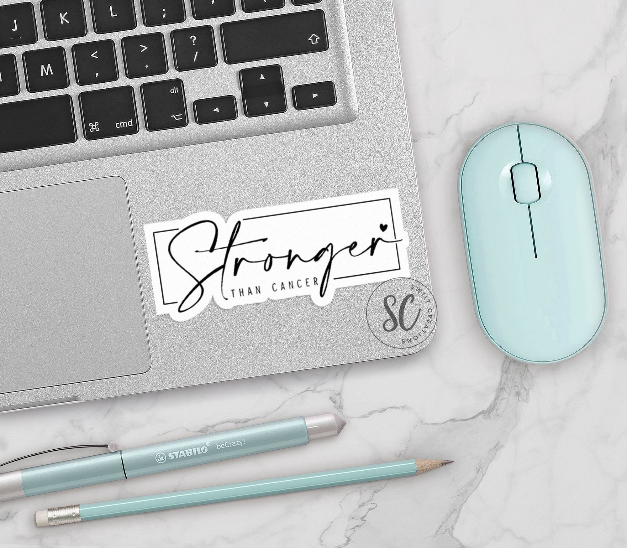 a laptop with a sticker on it next to a mouse