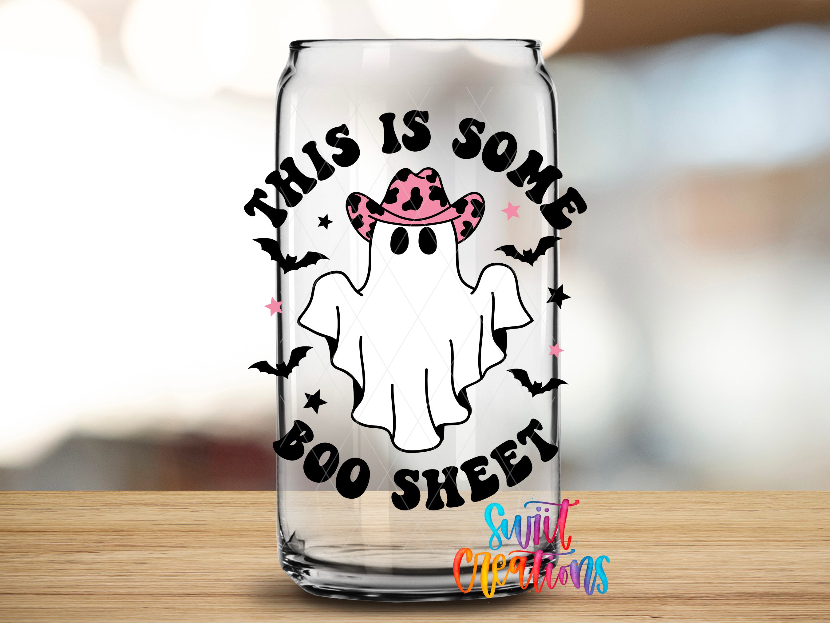 A glass can with a Halloween-themed design featuring a ghost wearing a cowboy hat and the text "This is some BOO sheet" printed on it.