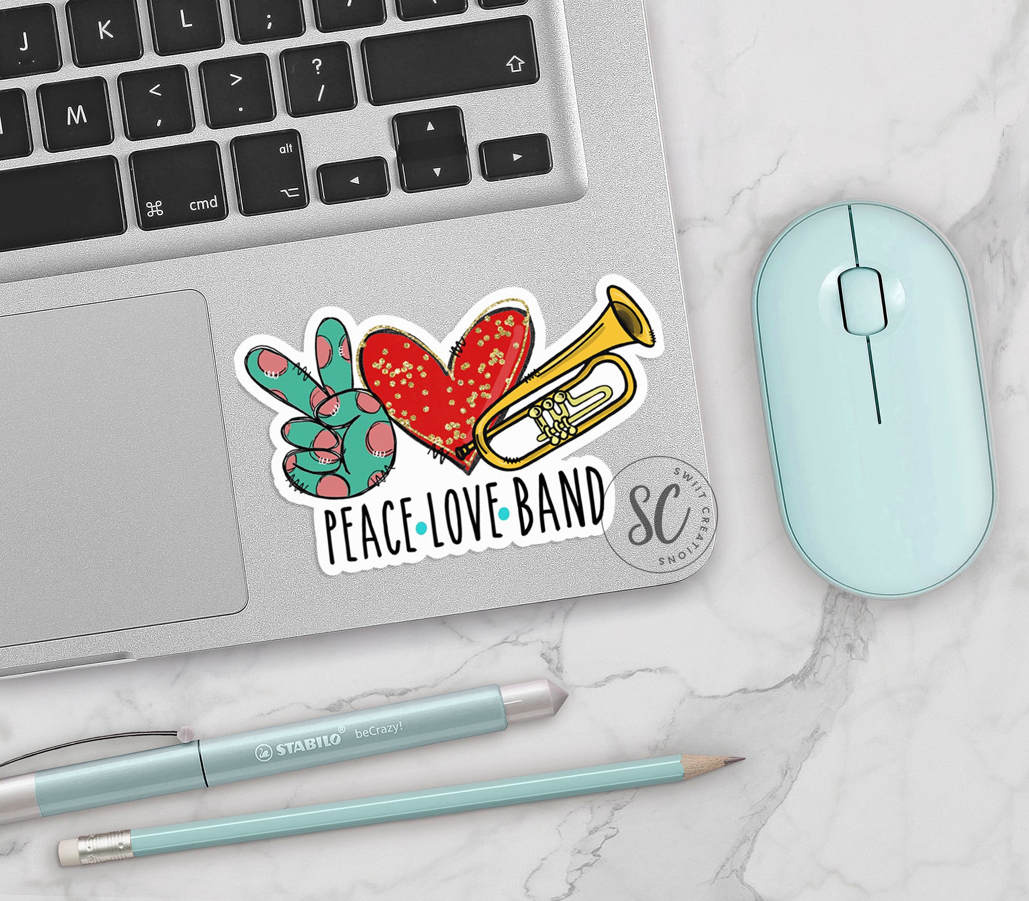 a laptop with a sticker of a trumpet and a heart