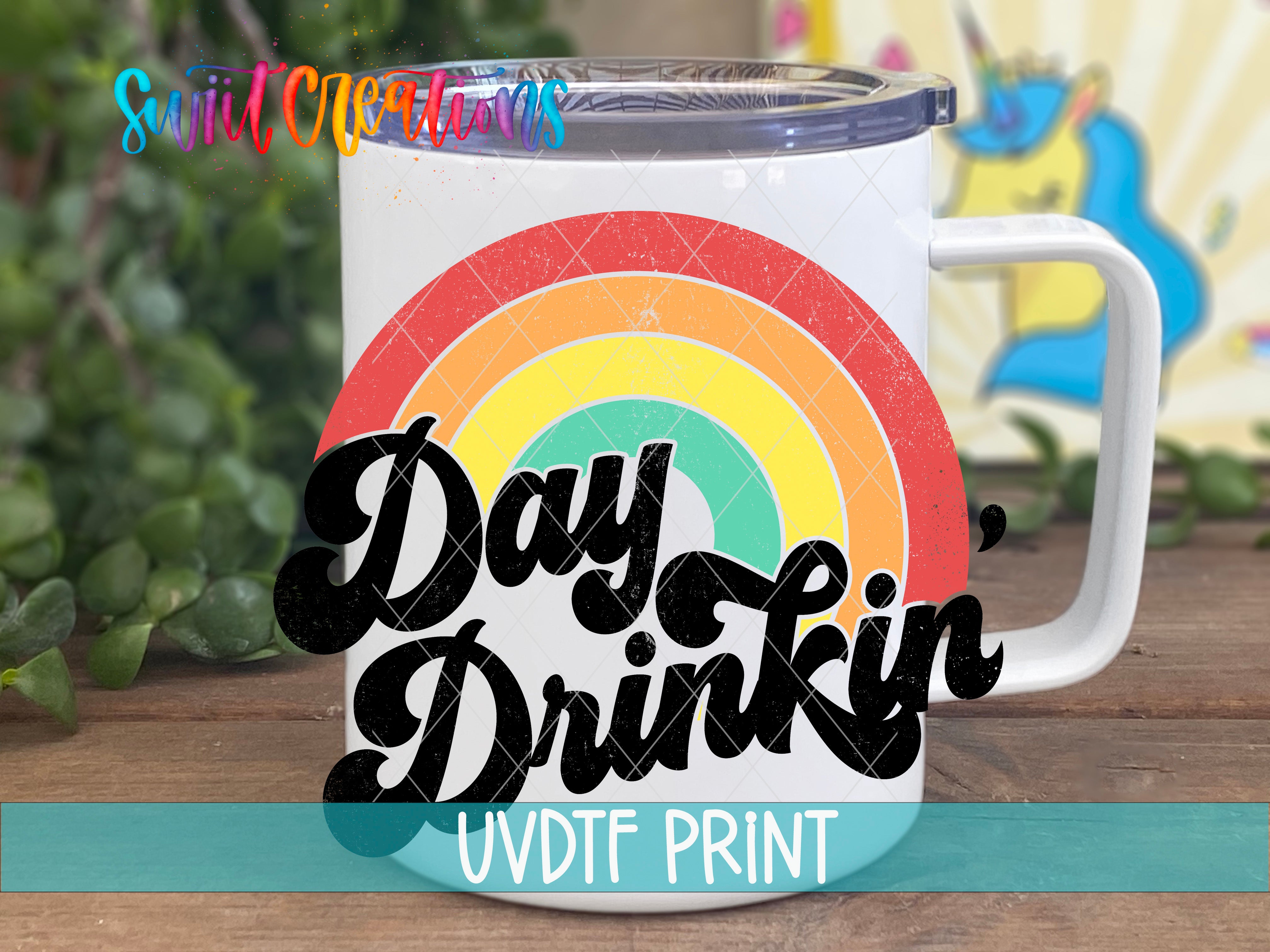 A white mug with a colorful rainbow design and the text "Day Drinking" printed on it.