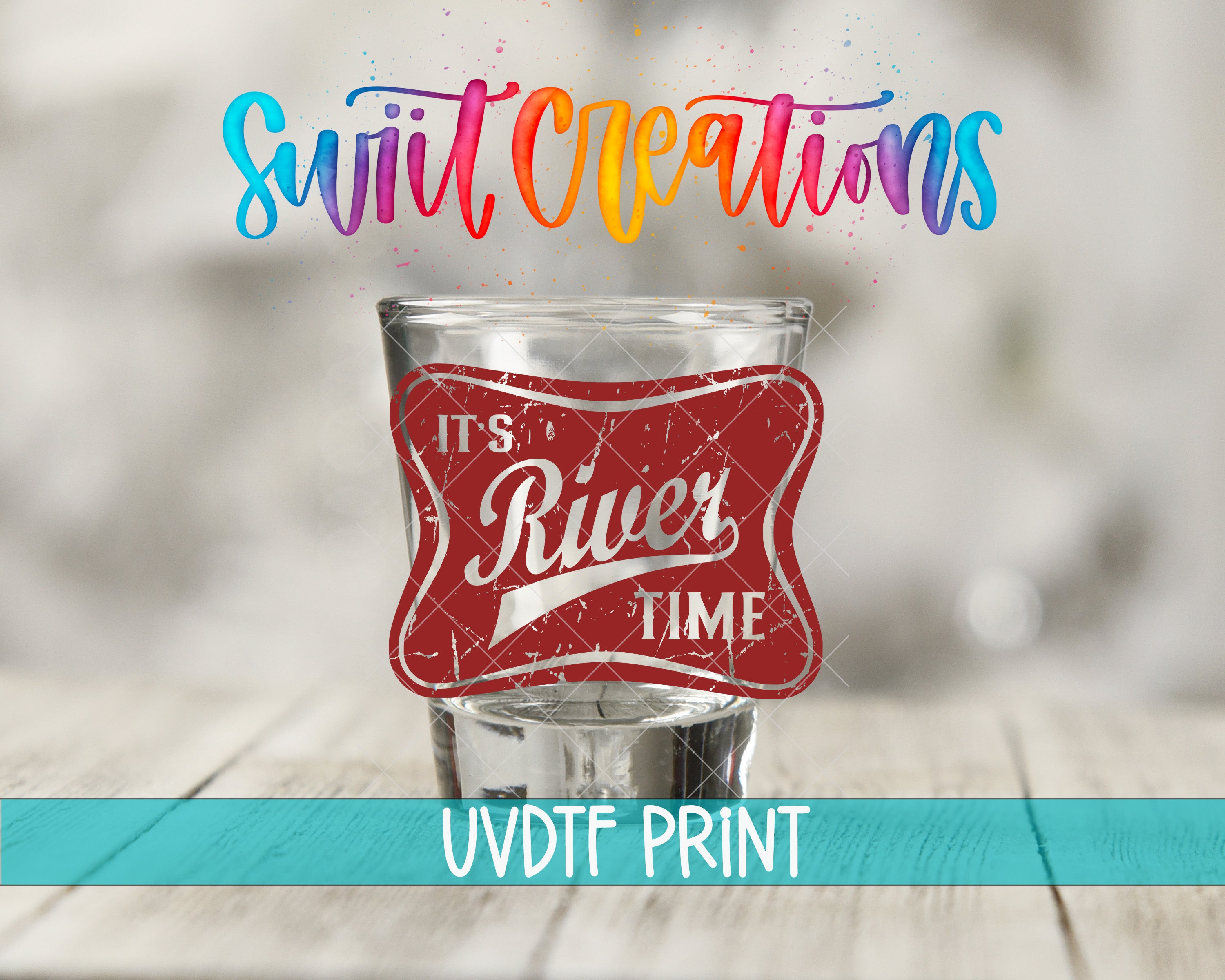 a shot glass with a red label that says "It's a River Time" and is placed on a wooden surface.