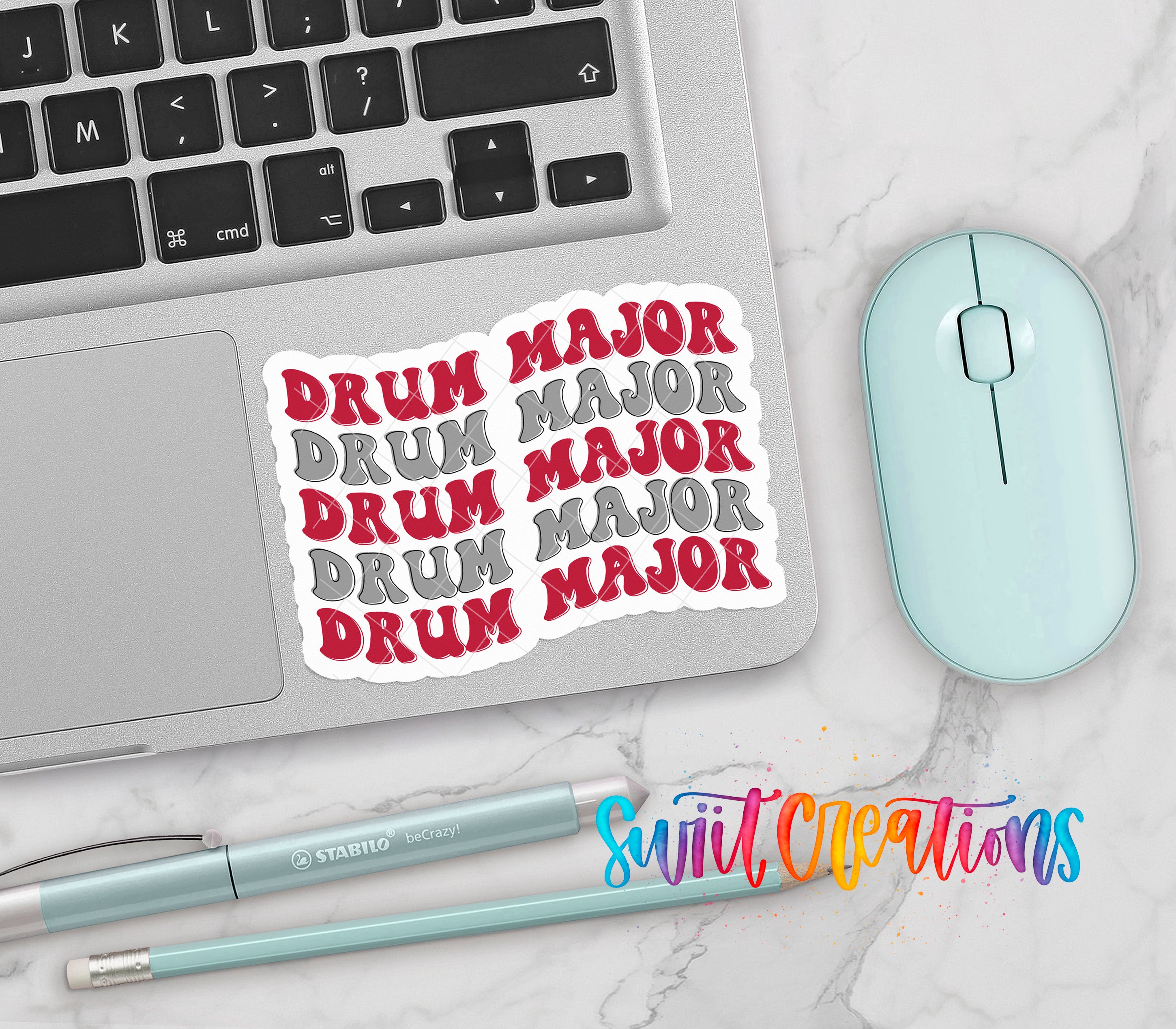 a laptop, a mouse, and various office supplies such as pens and pencils, all arranged on a marble surface.