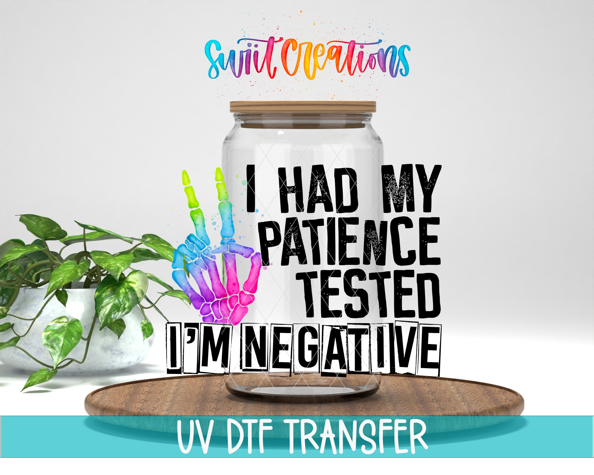a glass jar with a hand-painted skeleton hand and the text "I HAD MY PATIENCE TESTED I'M NEGATIVE" printed on it. The jar is placed on a wooden surface, and there is a potted plant in the background.