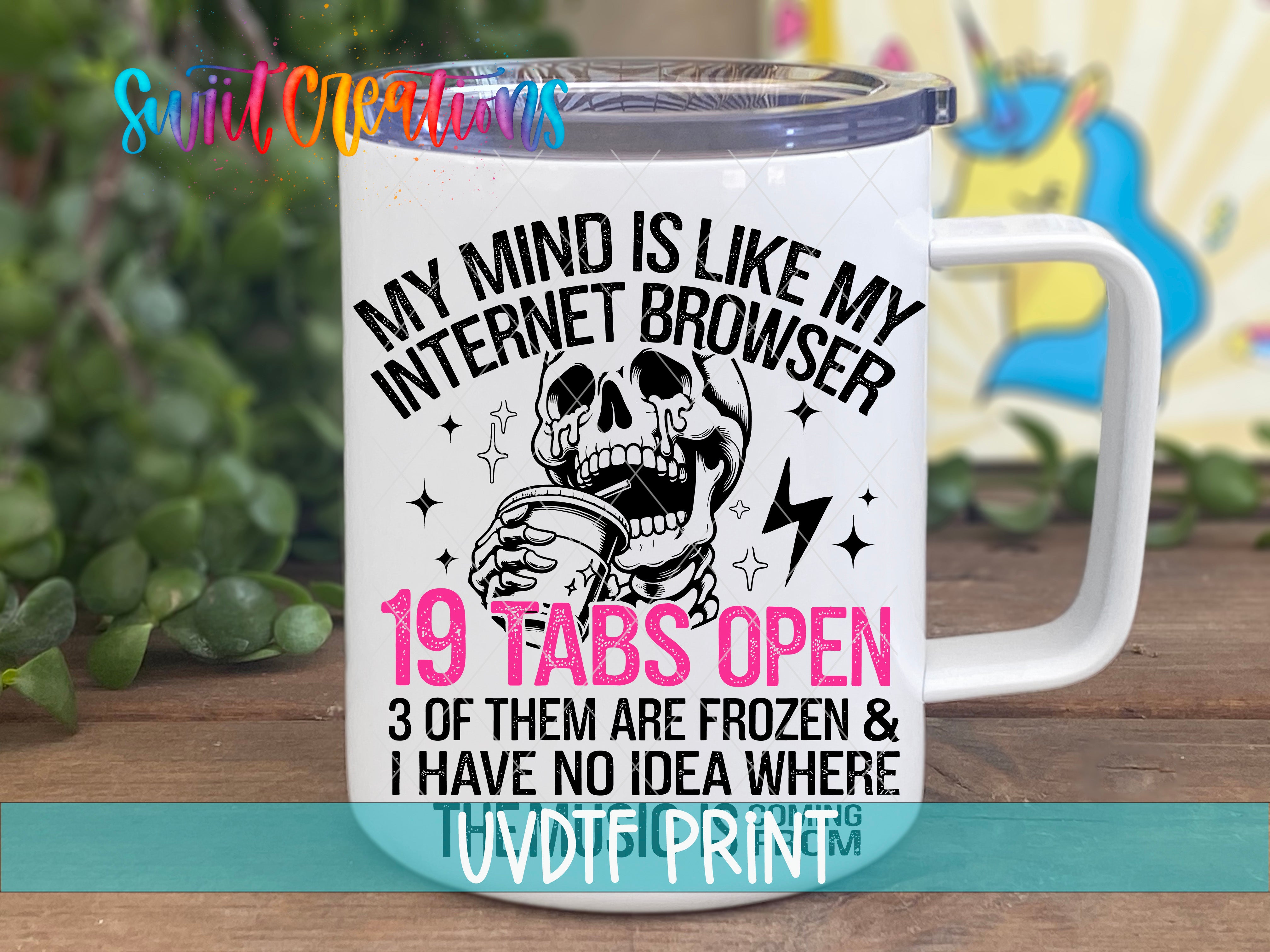 A white mug with a humorous text and graphic design printed on it, placed on a wooden surface.