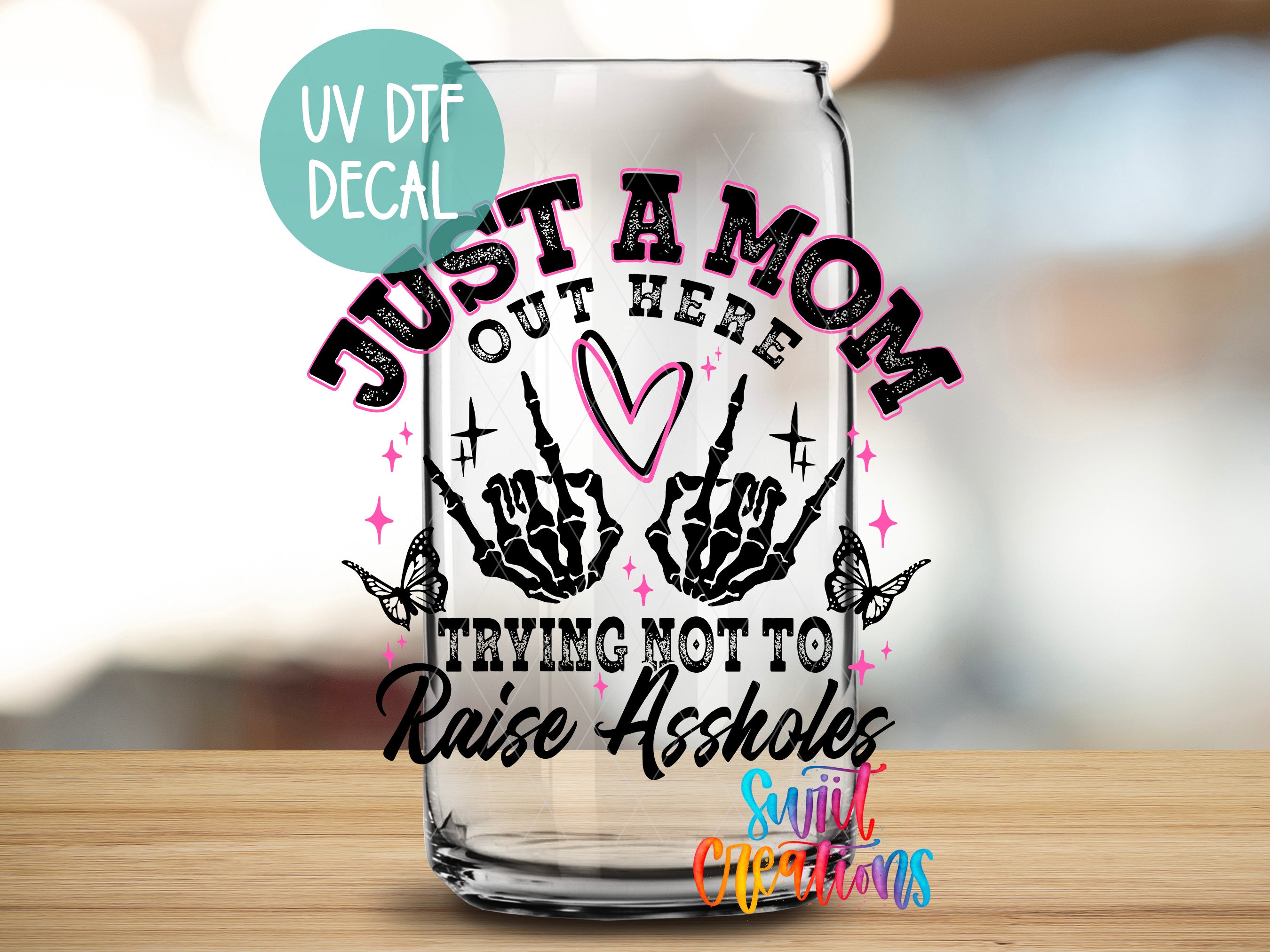 a shot glass with the words just a mom out here trying not to raise aside