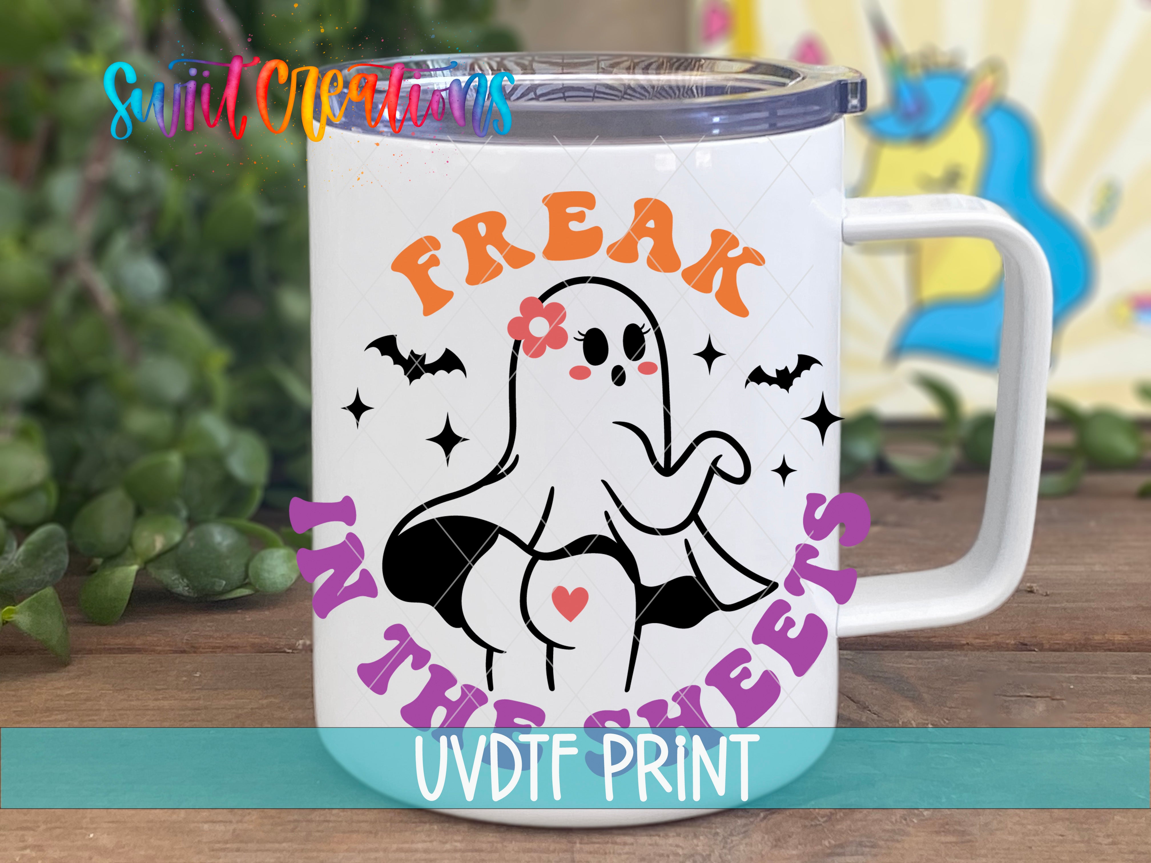A white mug with a graphic design featuring a ghost character and the text "Freak in the Sheets" printed on it.