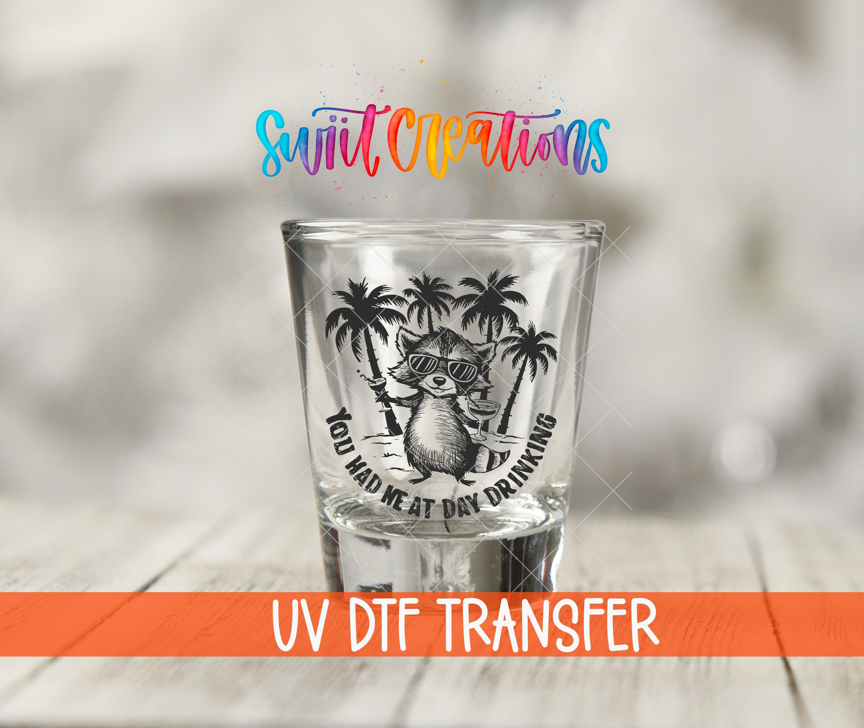 A shot glass with a graphic design featuring a raccoon wearing sunglasses and holding a drink, along with the text "You Had Me at Day Drinking" and "UV Dtf Transfer".