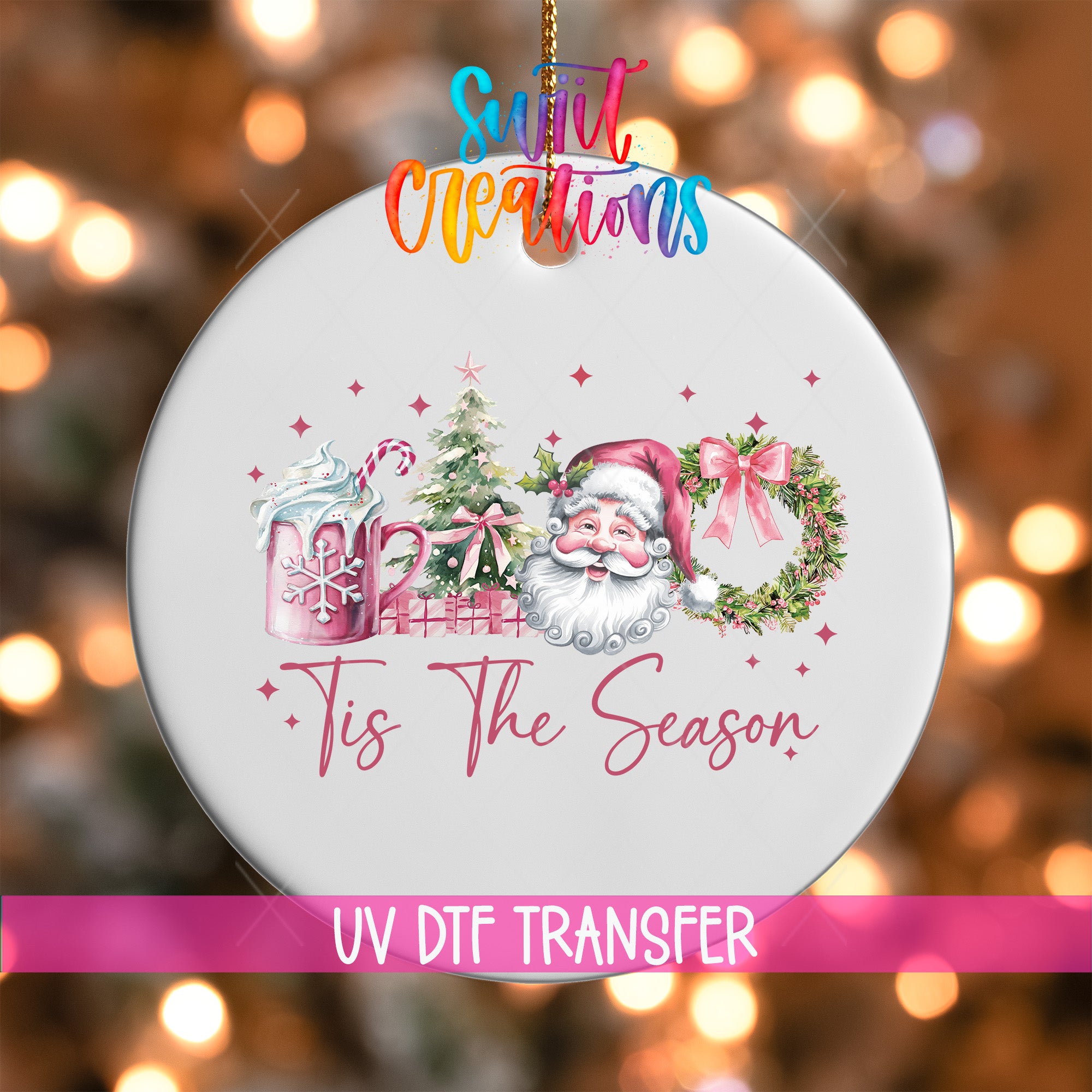 A white ornament with a Santa Claus design and the text "Tis The Season" is hanging against a background of colorful lights.