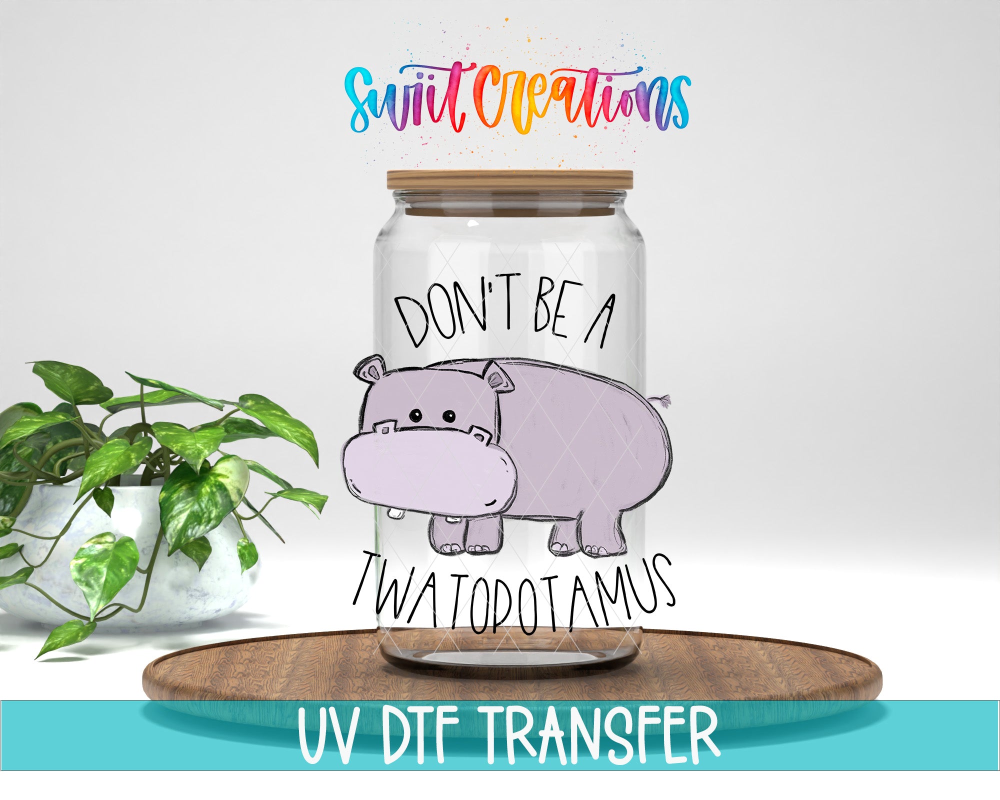 a glass jar with a cartoon image of a hippopotamus and the text "DON'T BE A TWATODOTAMUS" printed on it. The jar is placed on a wooden surface, and there is a potted plant in the background.