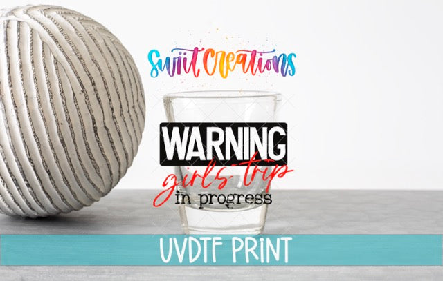 a glass of water with a ball of yarn next to it, along with text that reads "Swift Creations" and "WARNING girls trip in progress".