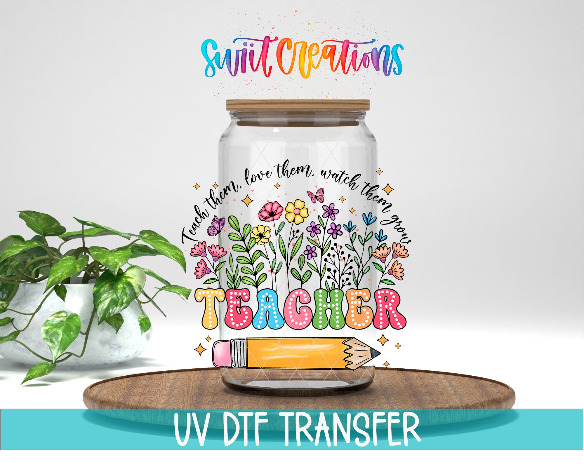 a glass jar with a colorful design, including flowers, leaves, and a pencil, along with the word "Teacher" written on it. The jar is placed on a wooden surface, and there is a potted plant in the background.
