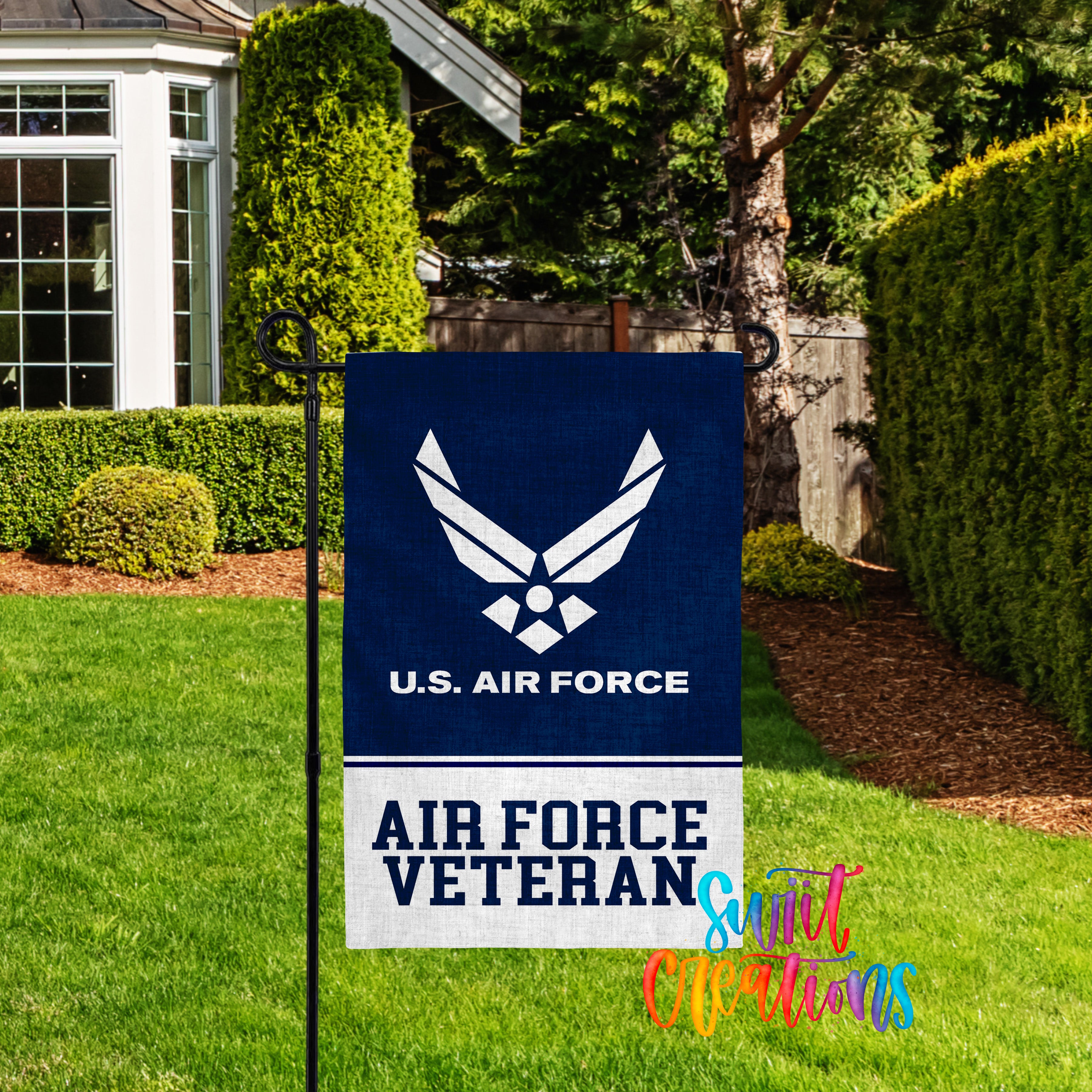 A blue flag with the U.S. Air Force logo and the text "AIR FORCE VETERAN" is displayed in a grassy yard, with a house and trees in the background.