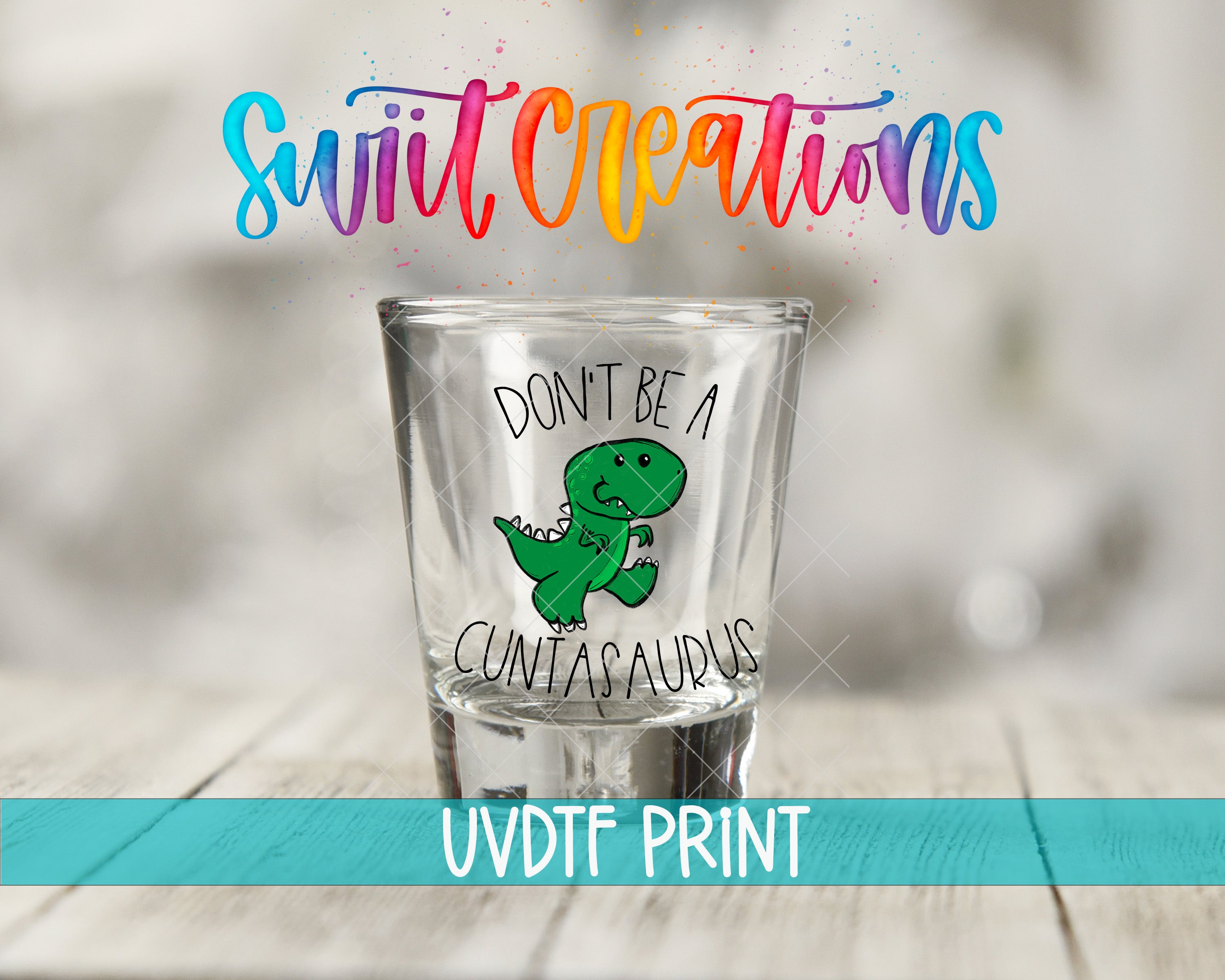 A shot glass with a cartoon dinosaur and text printed on it, along with colorful text above the shot glass.