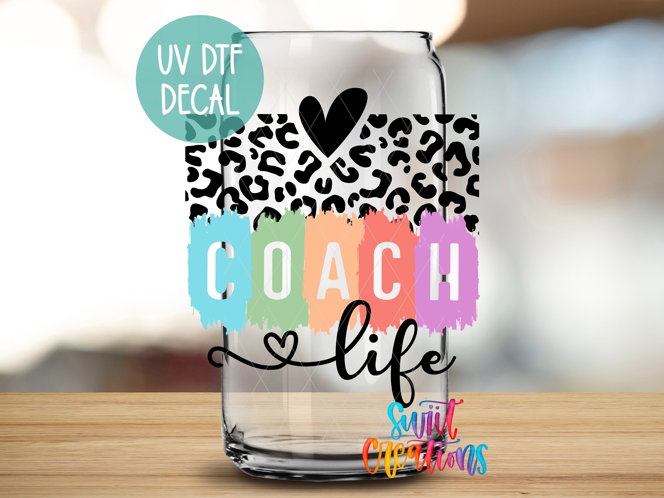 A transparent glass with a leopard print design and the text "COACH life" printed on it.
