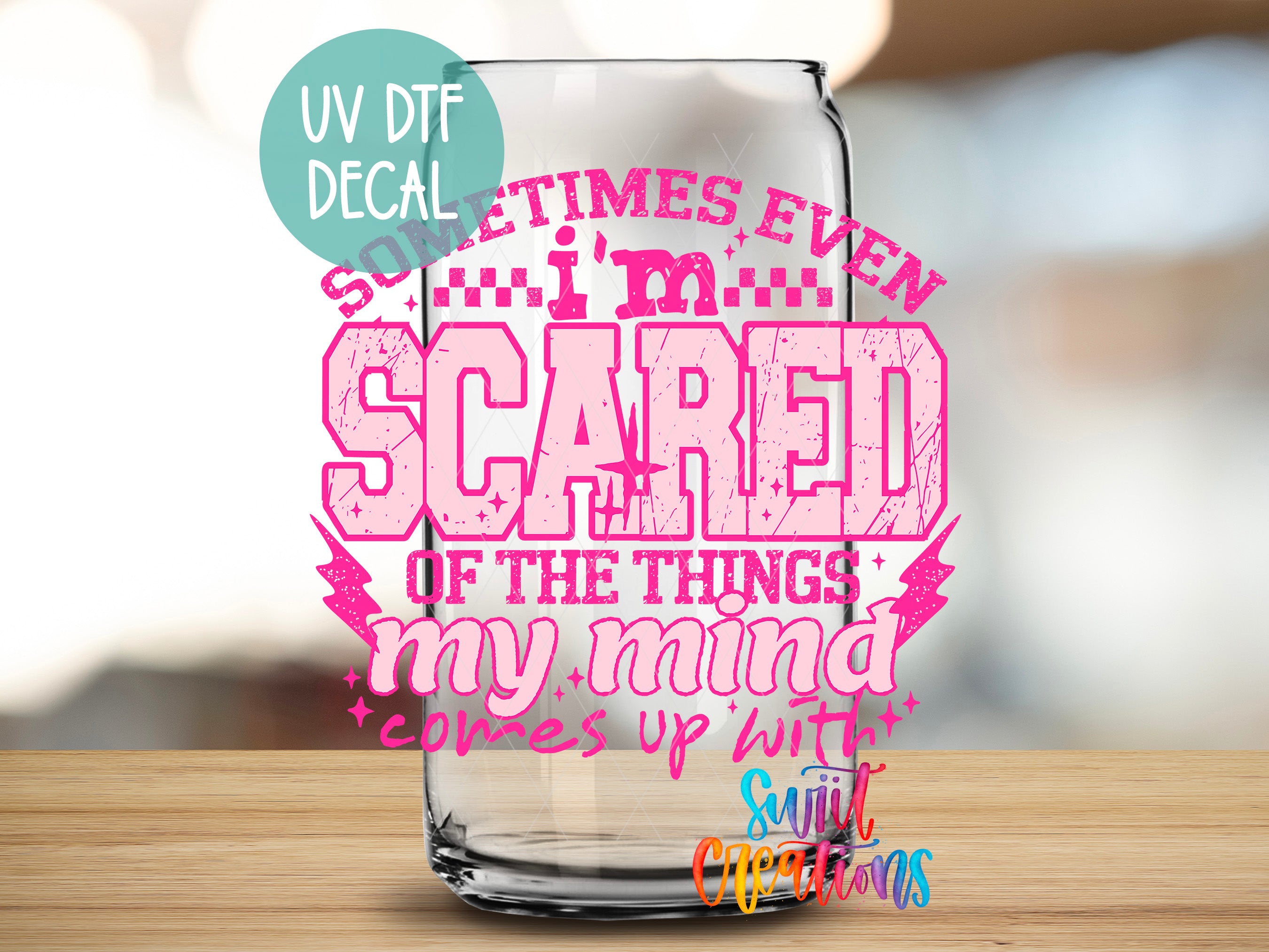 a glass can with a text design on it, placed on a wooden surface.