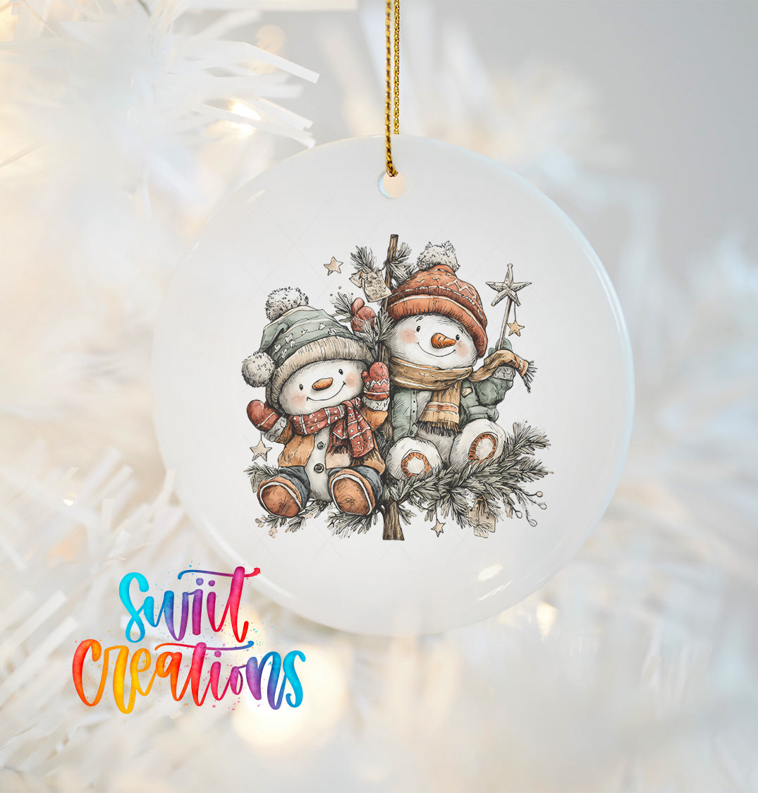 A white ornament with a snowman and star on a branch, hanging on a tree.