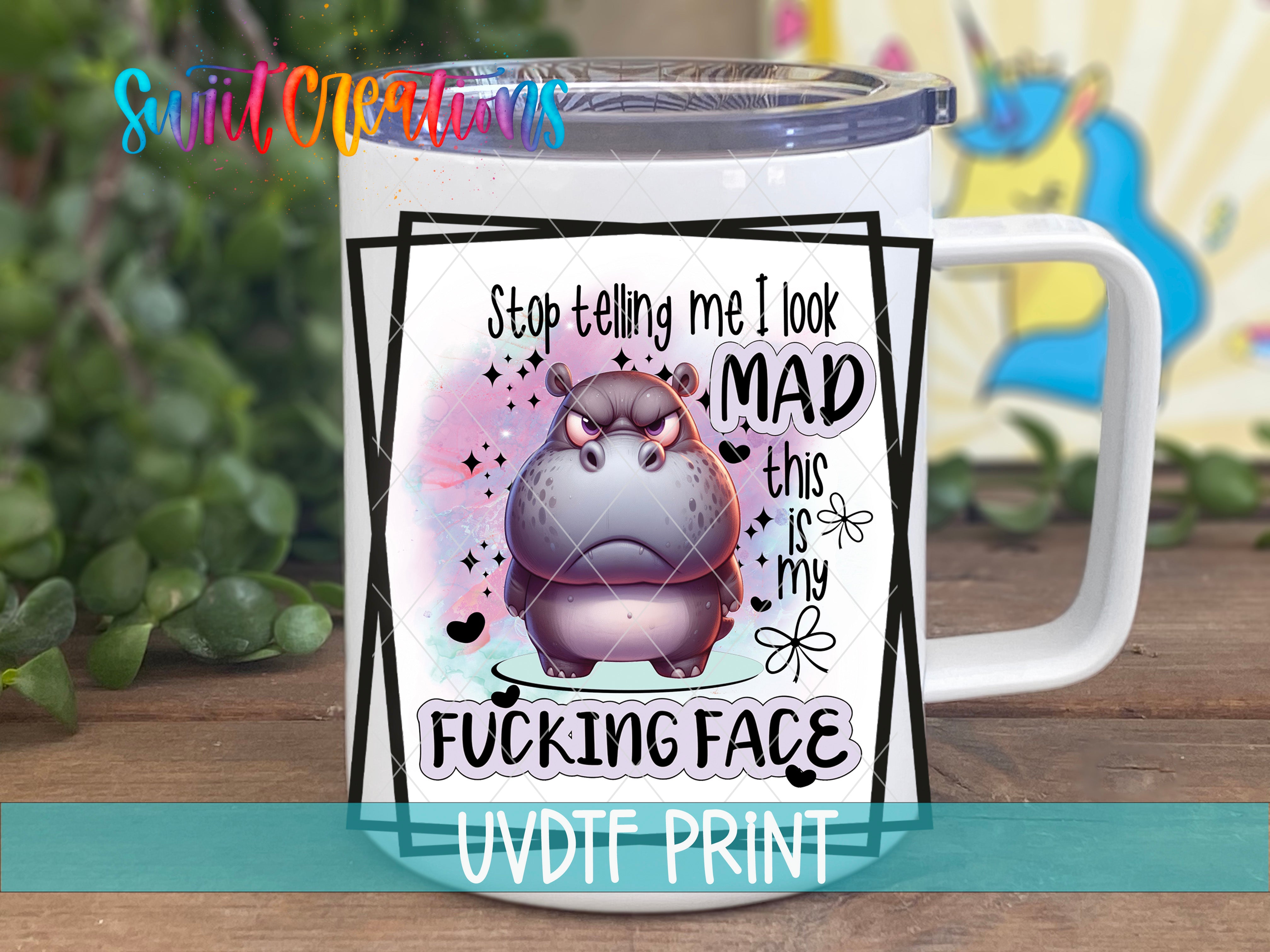 A mug with a cartoon hippo and text that says "Stop telling me I look MAD this is my FUCKING FACE" printed on it.