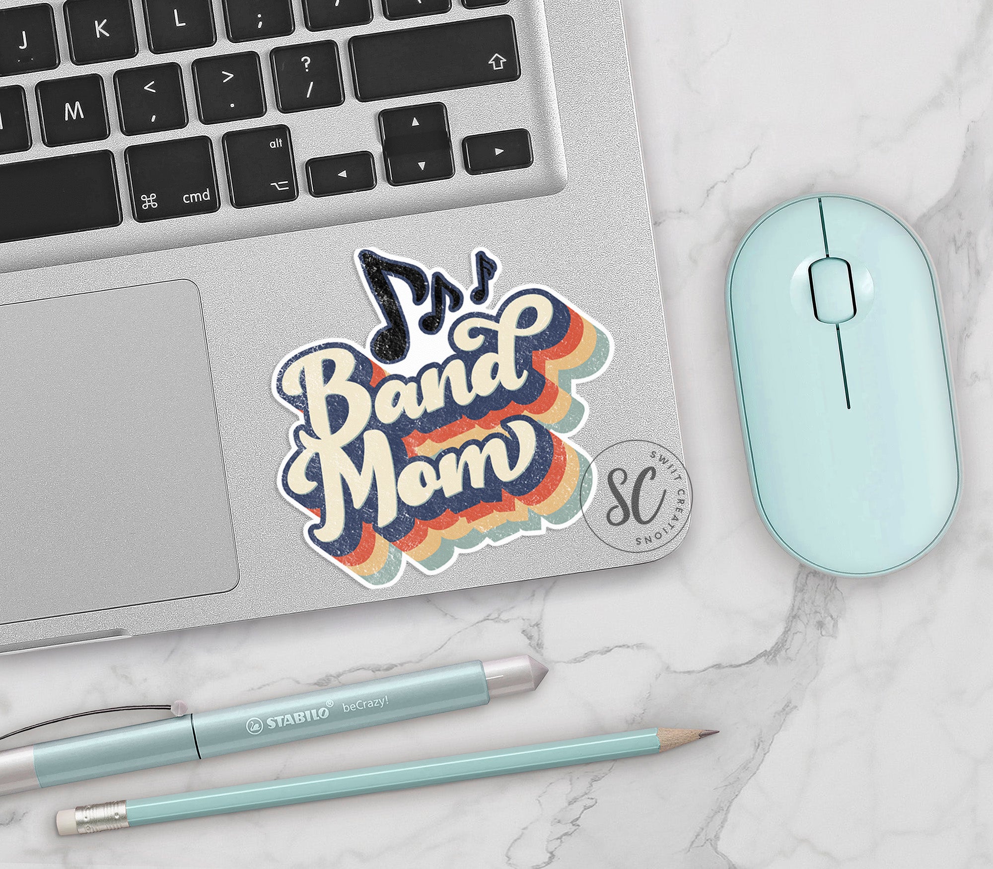 a laptop with a sticker on it next to a mouse