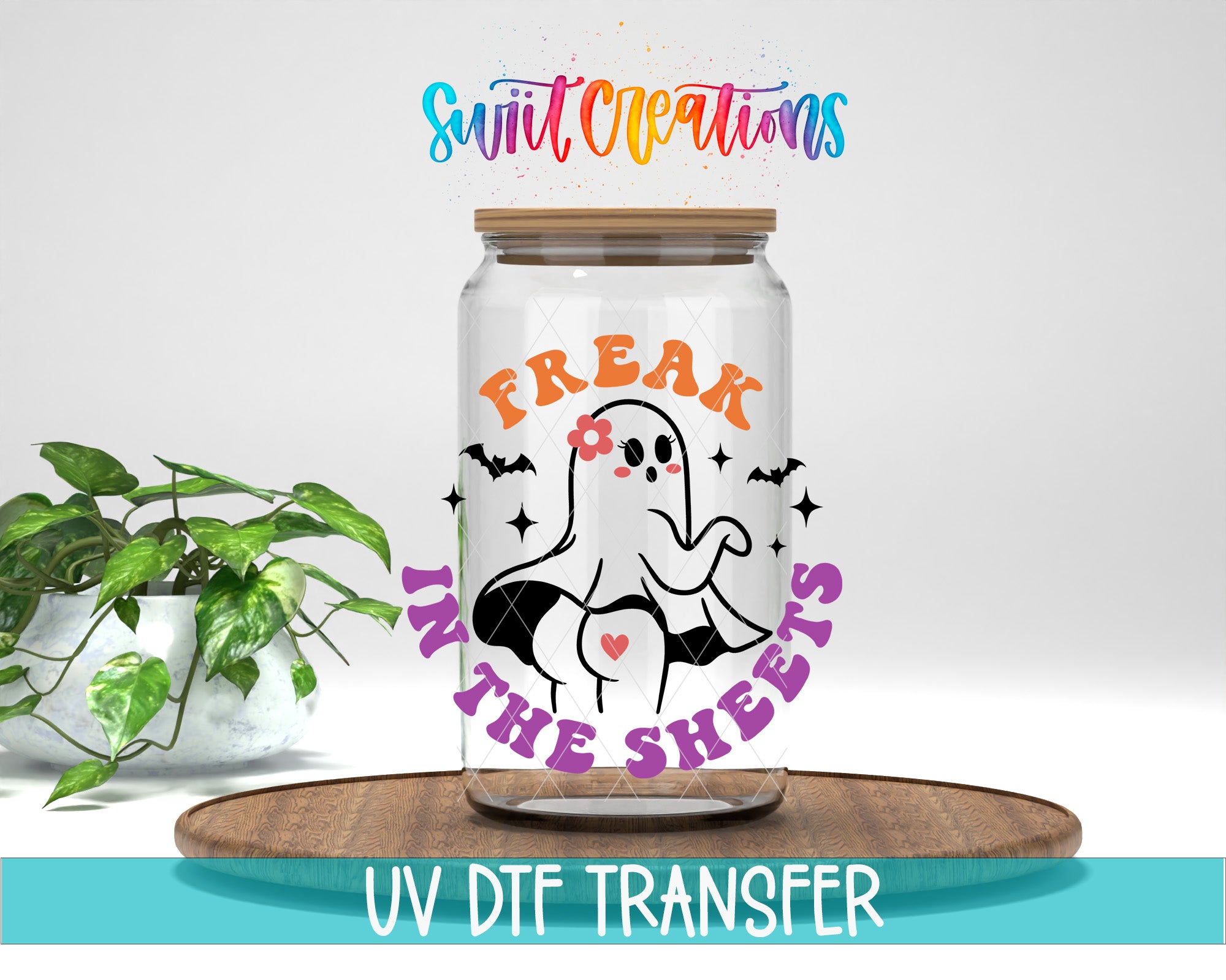 a glass jar with a Halloween-themed design, including a ghost and the text "FREAK IN THE SHEETS" printed on it. The jar is placed on a wooden surface, and there is a potted plant in the background.