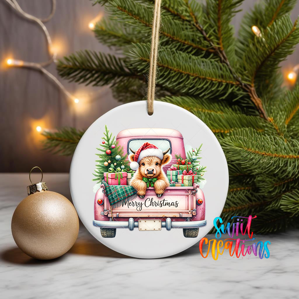 A ceramic ornament featuring a cartoon cow in a pink truck, surrounded by Christmas decorations and a Christmas tree.
