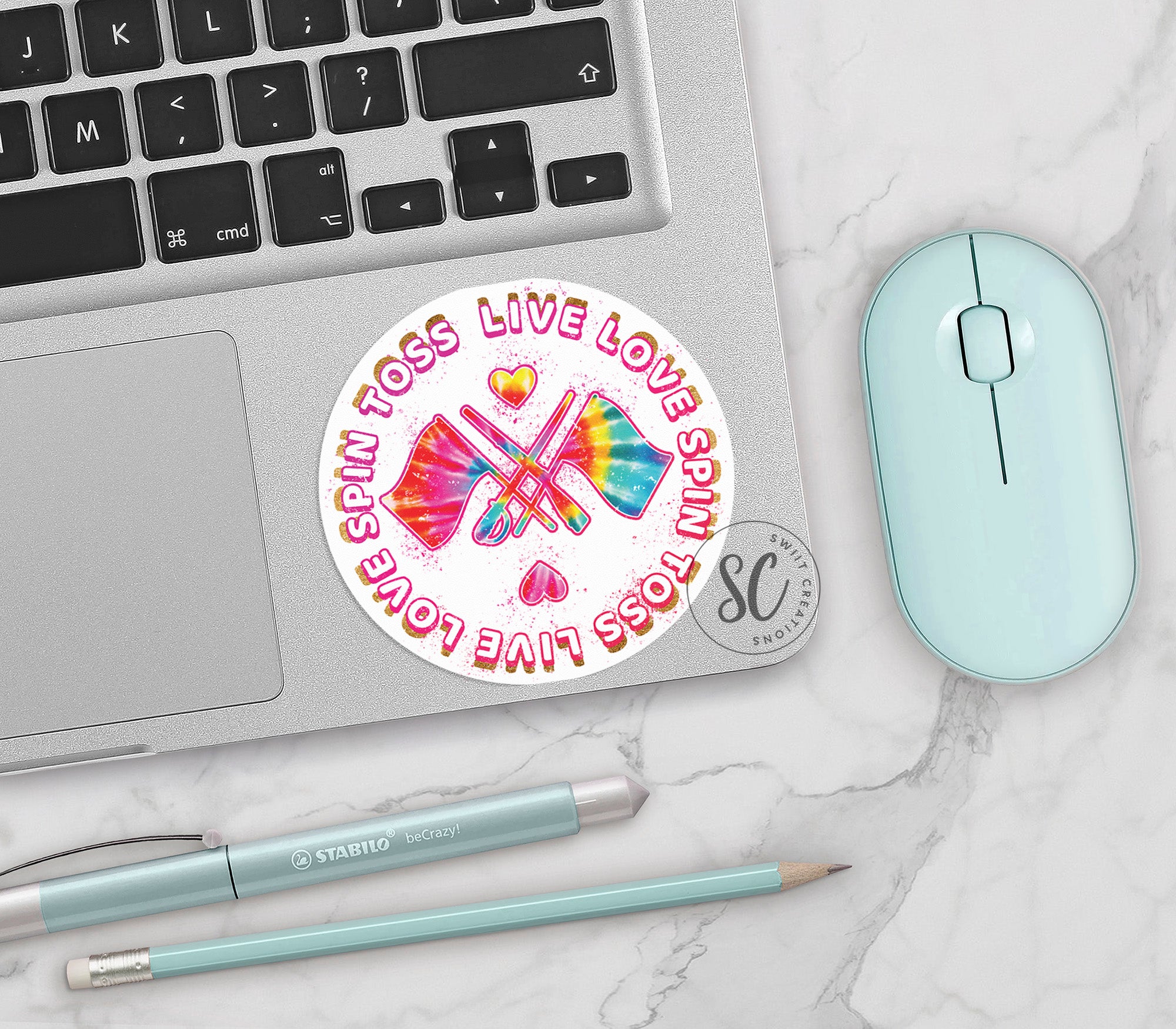 a computer keyboard, mouse, and sticker on a table