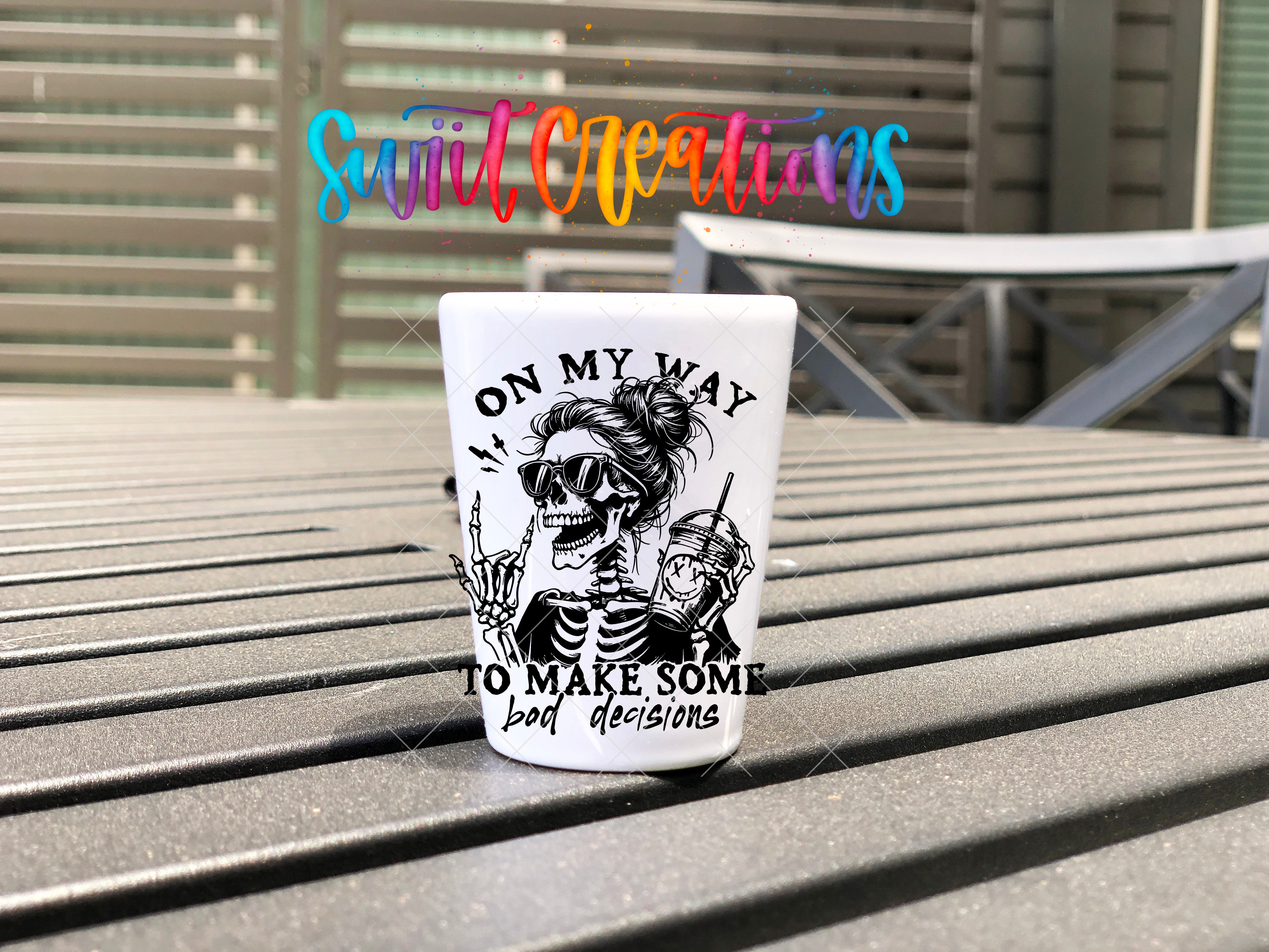 A white mug with a black and white illustration of a skeleton wearing sunglasses and holding a drink, along with the text "ON MY WAY TO MAKE SOME BAD DECISIONS" printed on it.