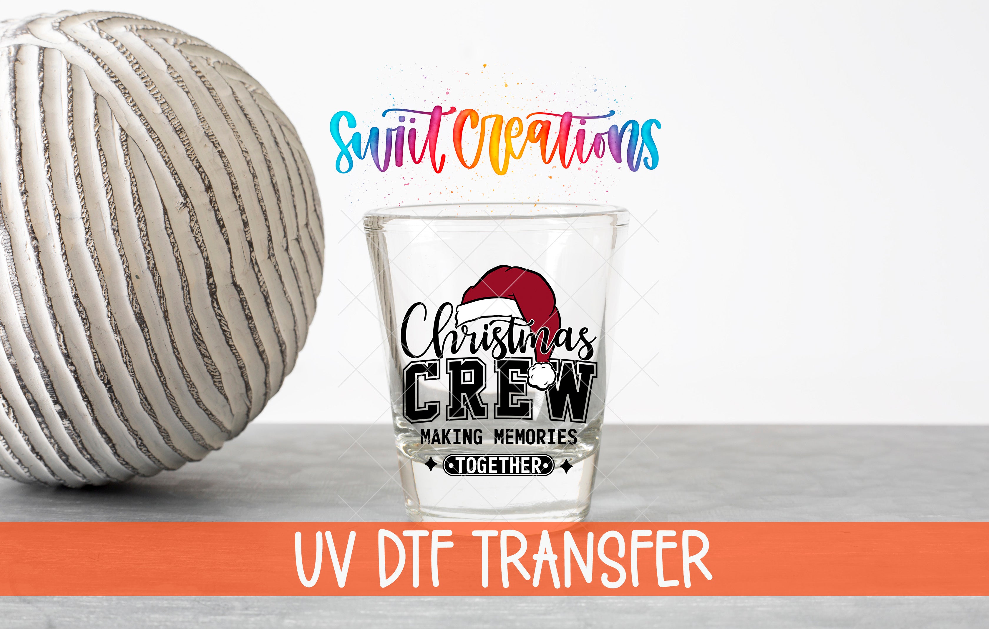 a glass with a Christmas crew design, along with a ball and text related to UV DFT transfer.
