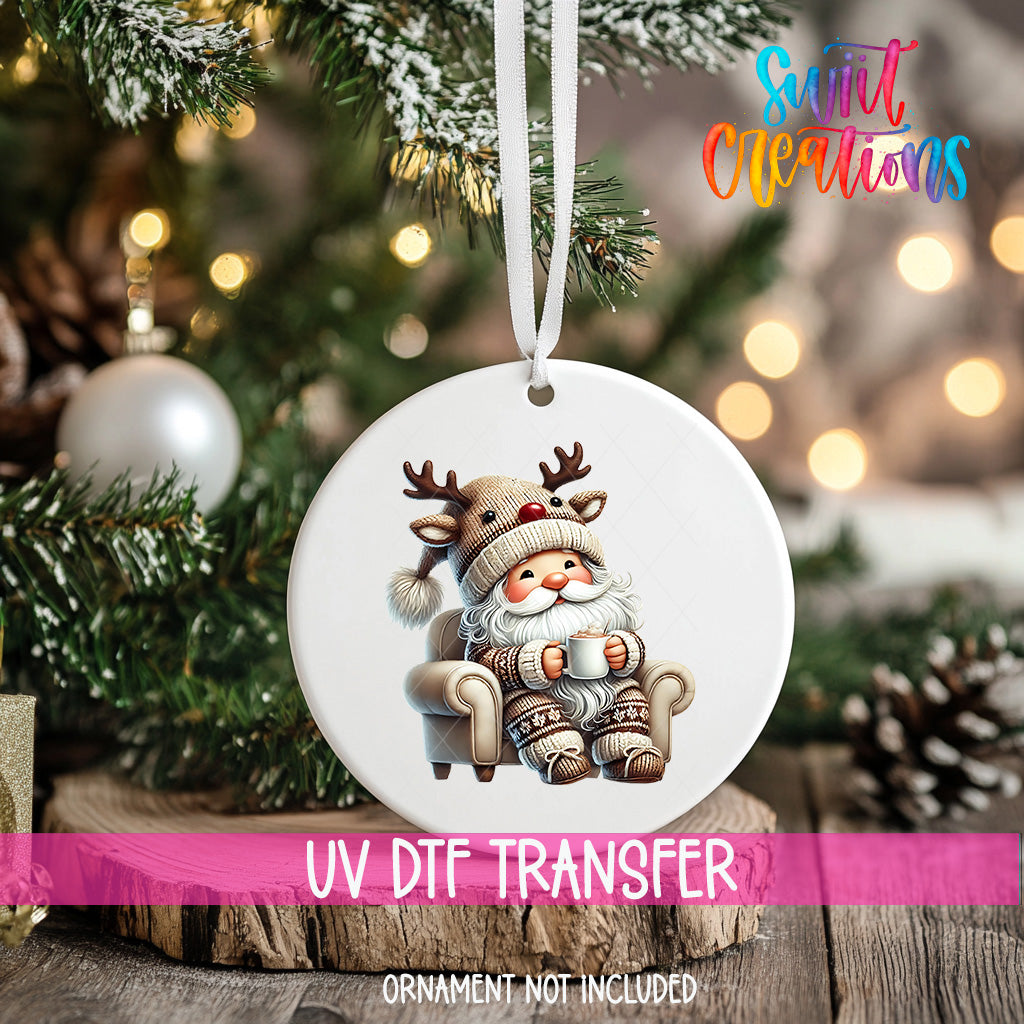 A white ornament with a Santa Claus reindeer sitting in a chair, surrounded by Christmas decorations and lights.