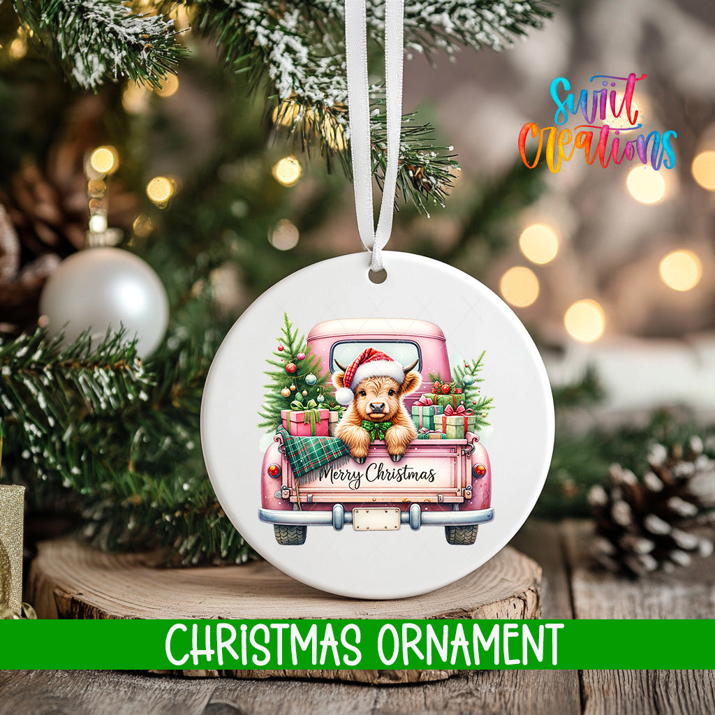 A Christmas ornament featuring a teddy bear in a pink truck, surrounded by Christmas decorations and lights.