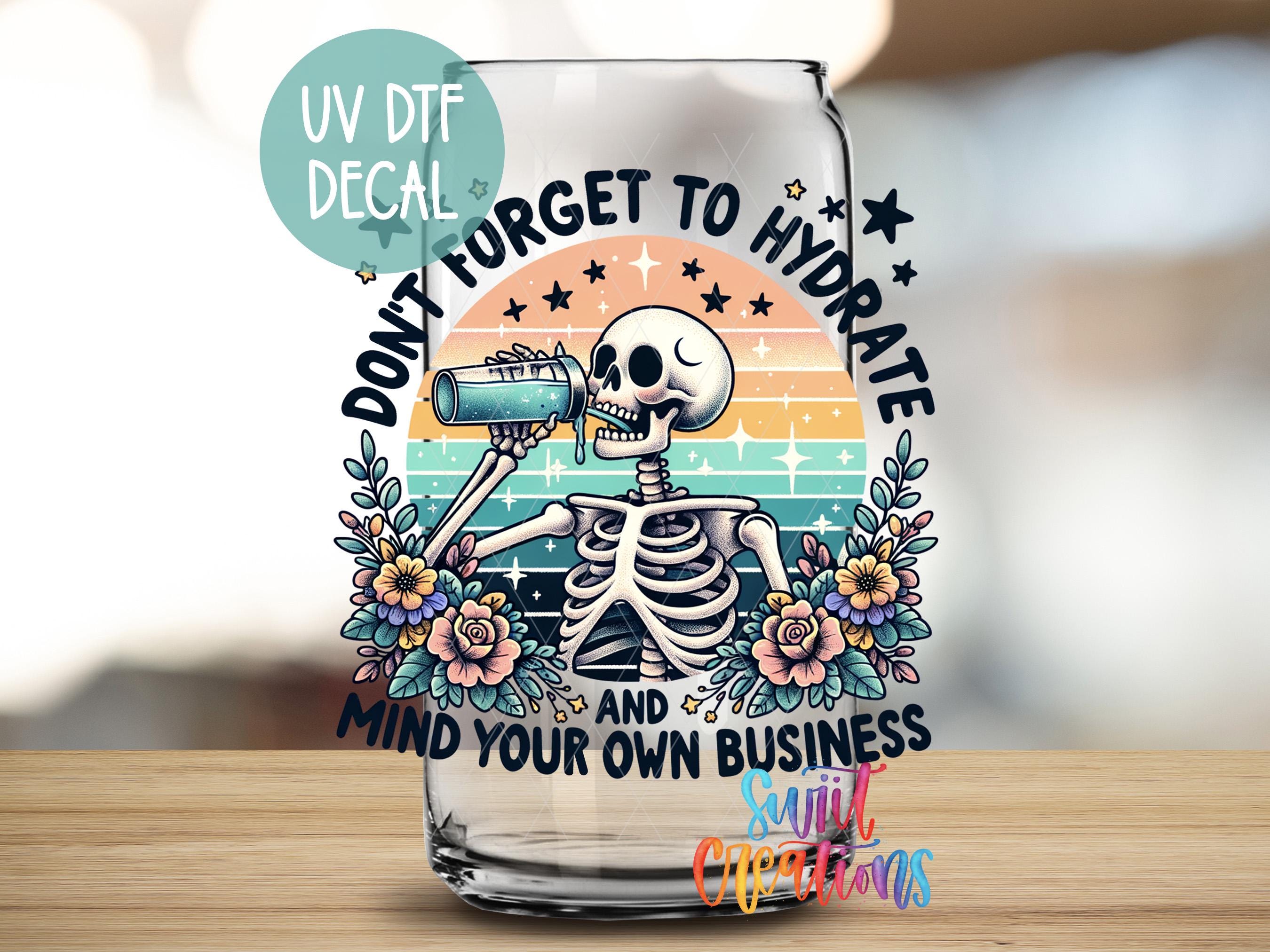 a glass with a skeleton on it sitting on a table