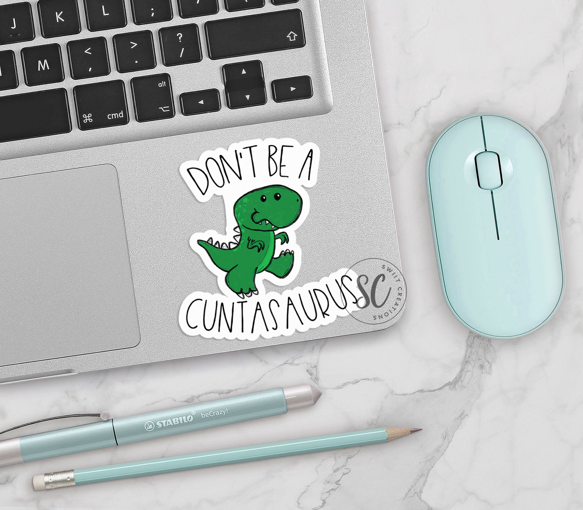 a laptop with a sticker of a dinosaur on it