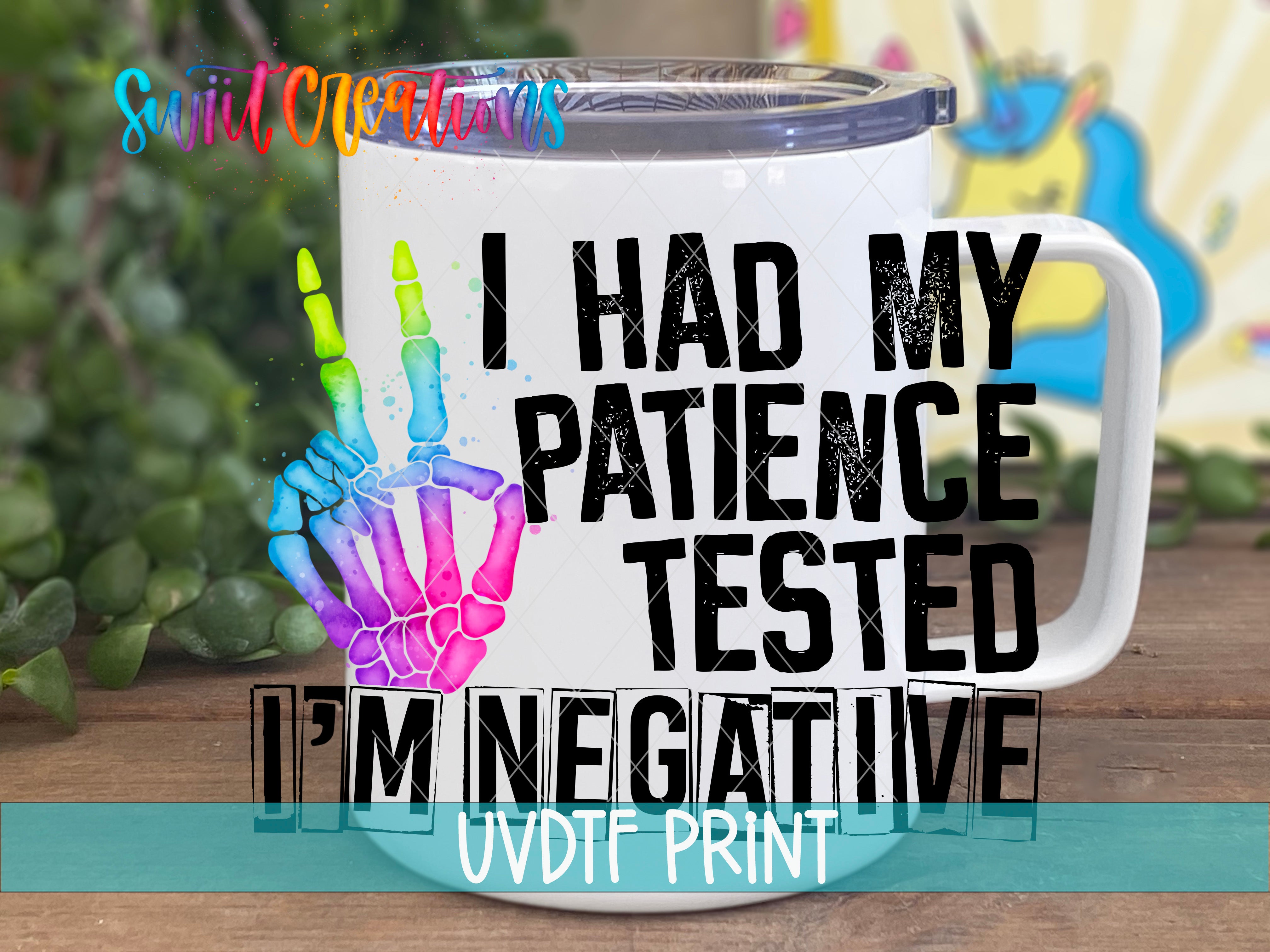 A white mug with a colorful skeleton hand and the text "I HAD MY PATIENCE TESTED I'M NEGATIVE" printed on it.