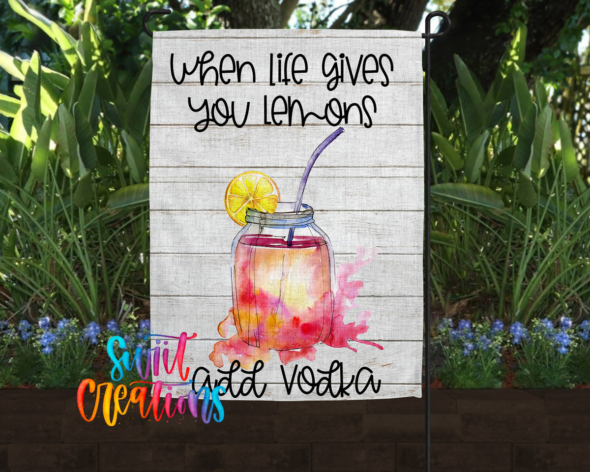 a sign with a lemon and a straw, accompanied by the text "When life gives you lemons, add vodka" in a wooden frame.