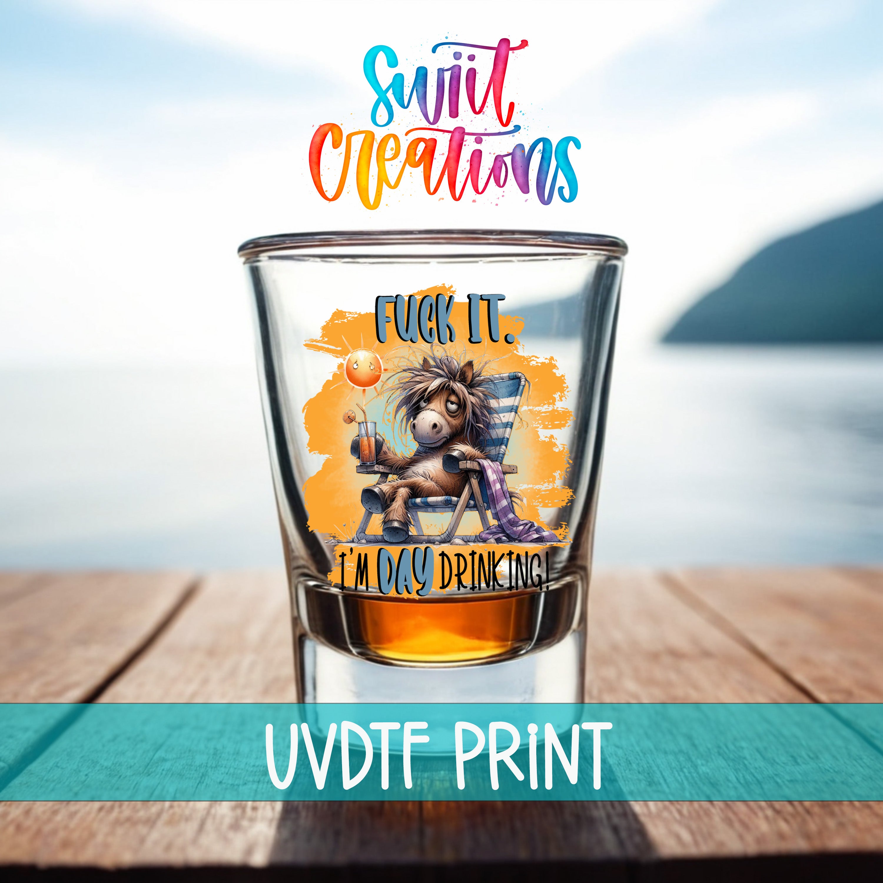 a shot glass with a cartoon character and text on it, placed on a wooden surface with a body of water in the background.
