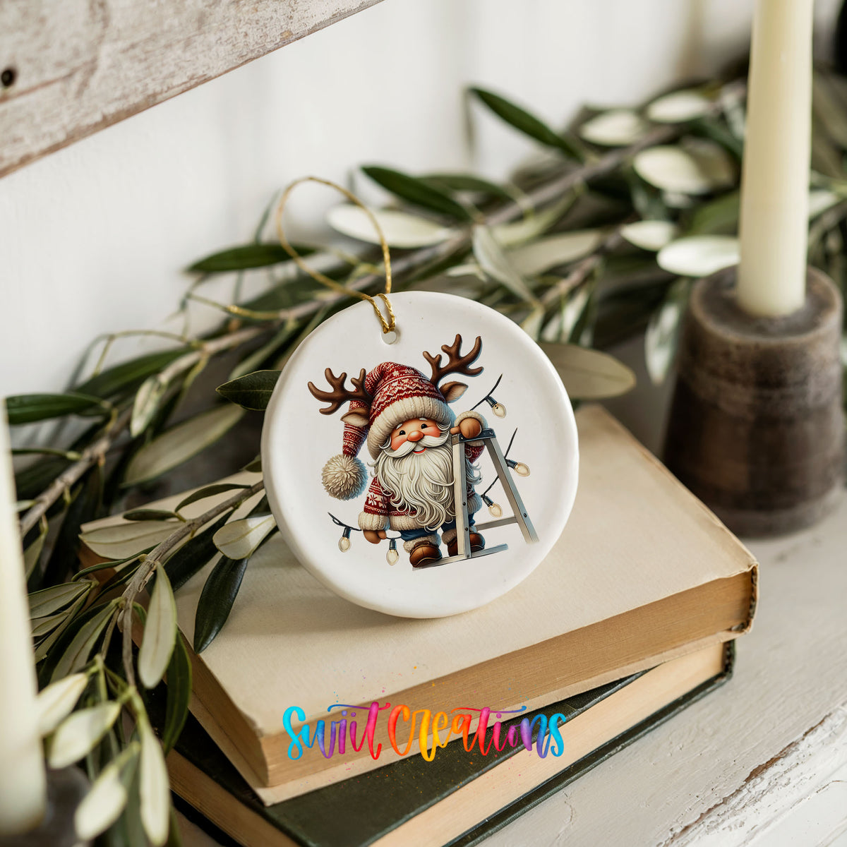 Santa decorating Christmas lights ceramic ornament styled on books with holiday greenery