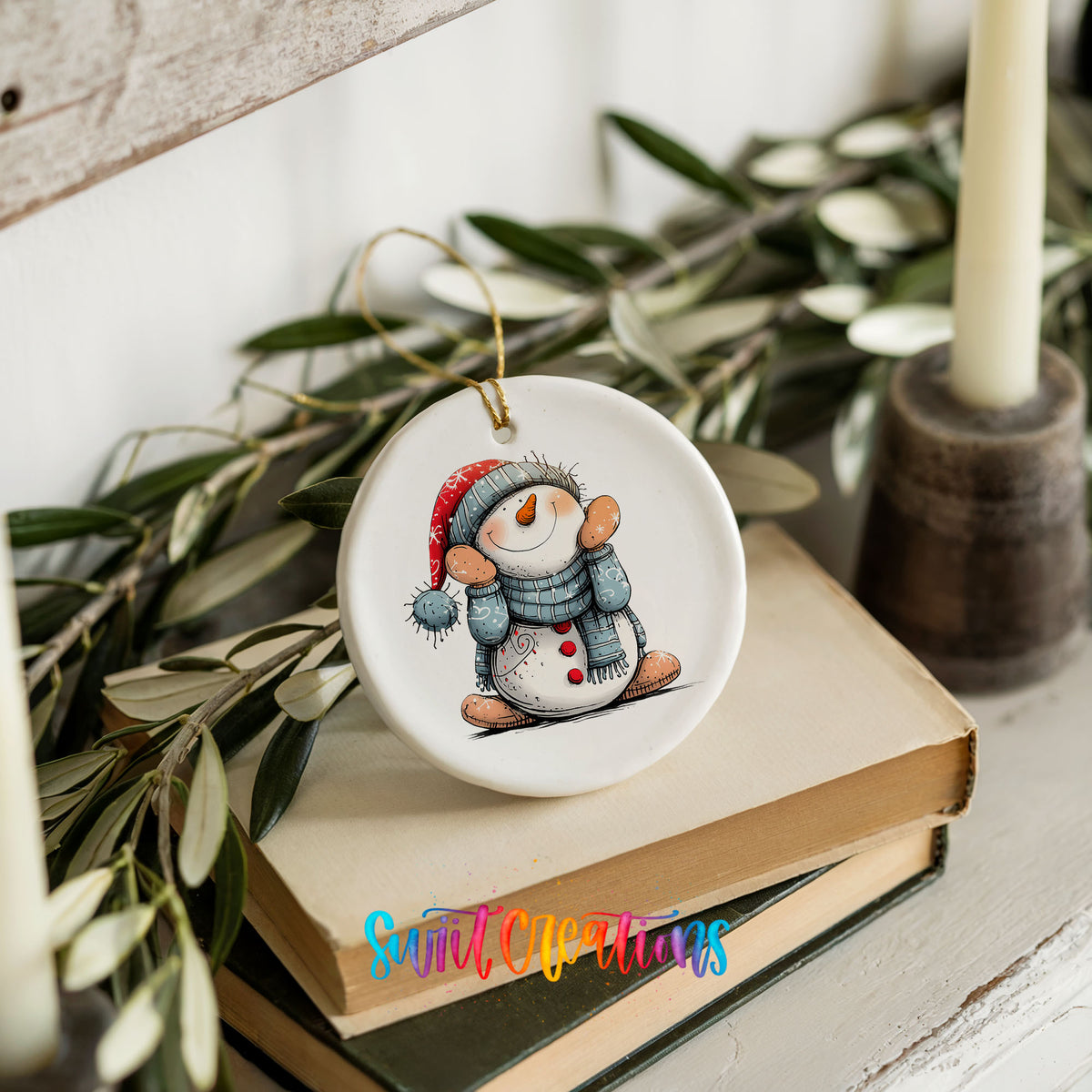Snowman in Blue Hat and Scarf Christmas ornament styled on books with holiday greenery