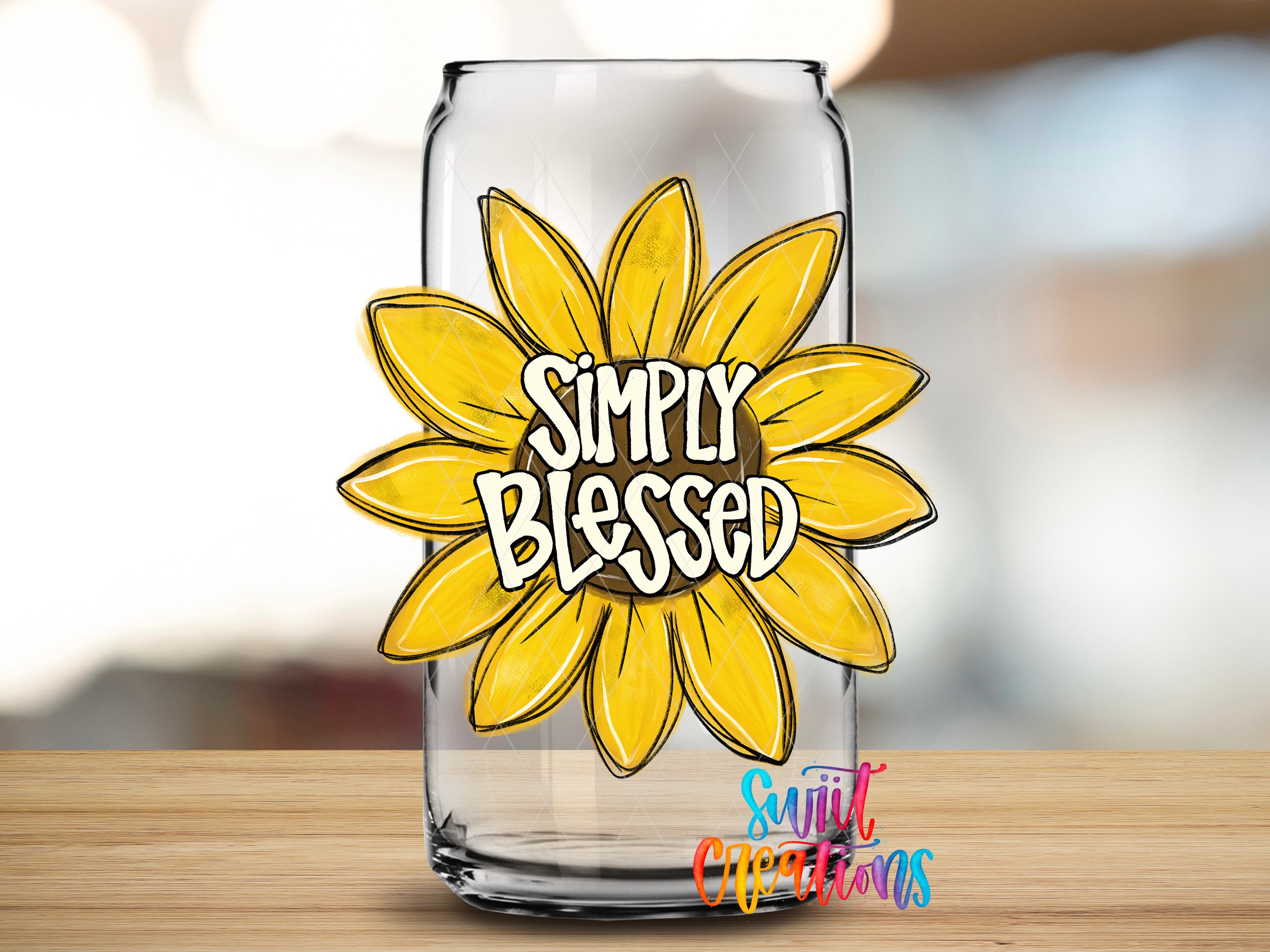 A clear glass can with a yellow flower design and the text "Simply Blessed" printed on it.