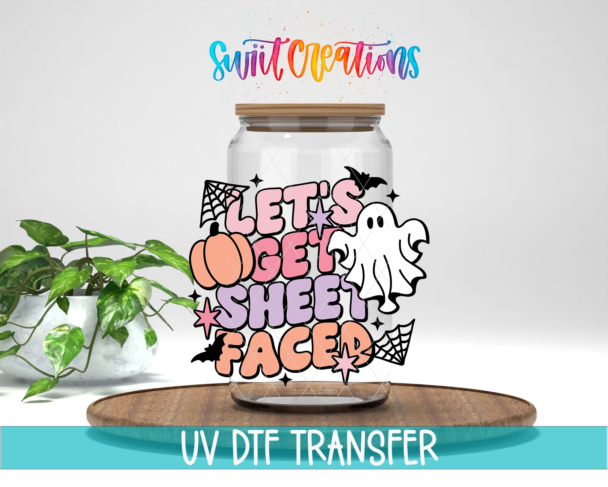 A glass jar with a Halloween-themed design, including a ghost, spider, and stars, along with the text "Let's get sheet faced" and "Swift Creations". The jar is placed on a wooden surface, and there is a potted plant in the background.