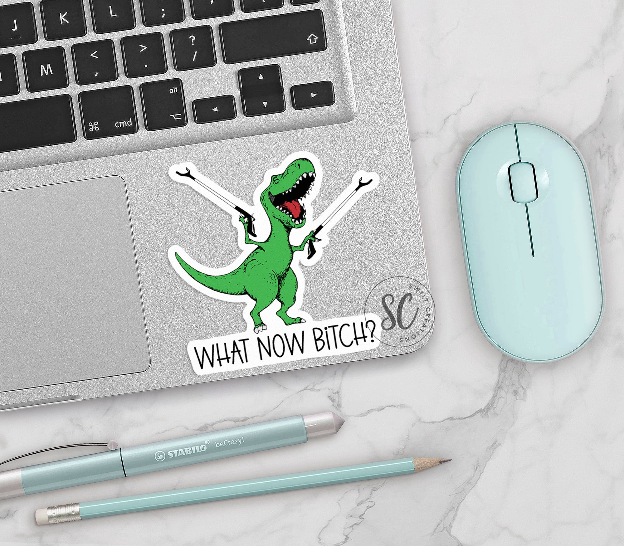 a laptop with a sticker of a dinosaur on it