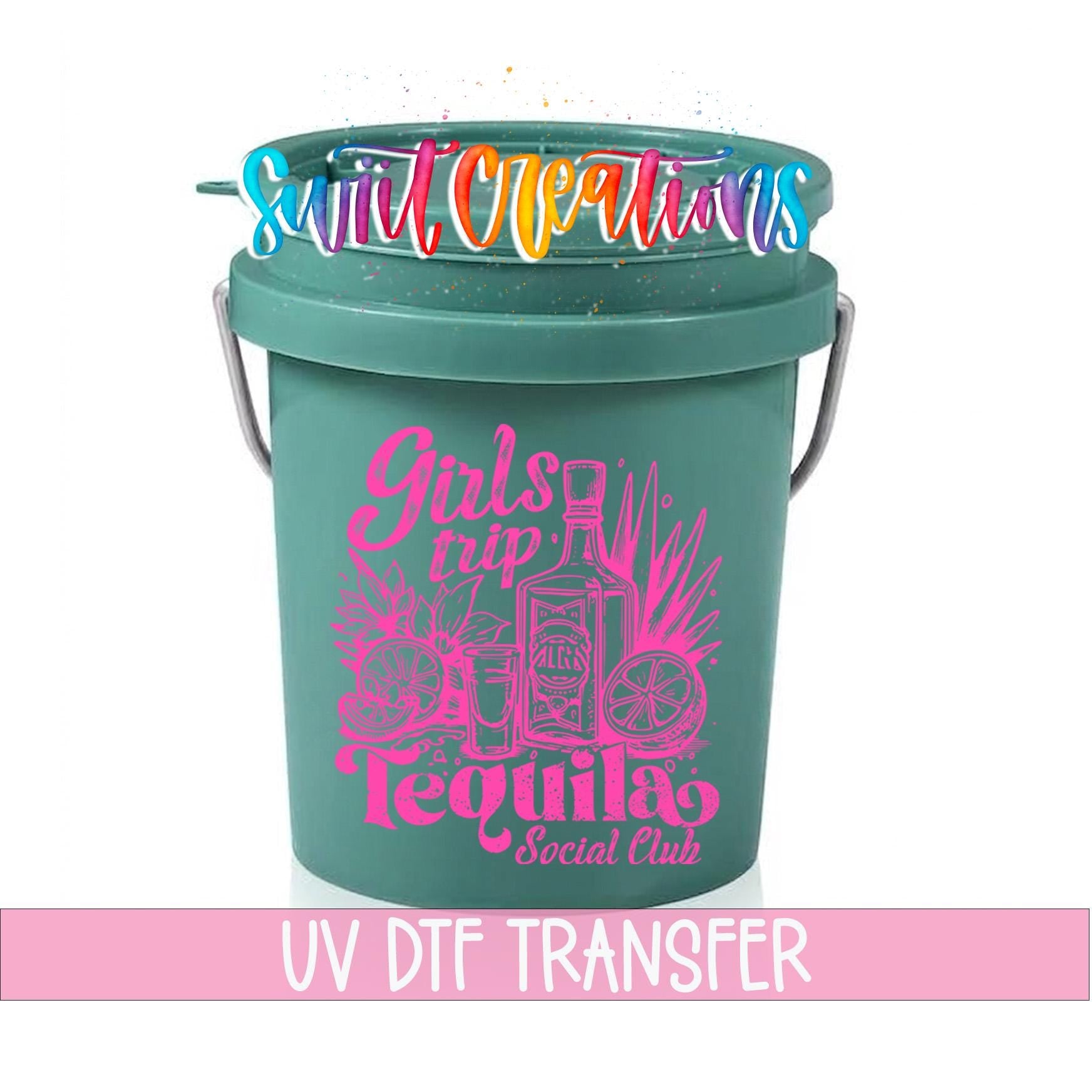 A green bucket with a pink and purple design featuring a tequila bottle and other icons, along with the text "Girls trip Tequila Social Club" and "UV DFT TRANSFER".