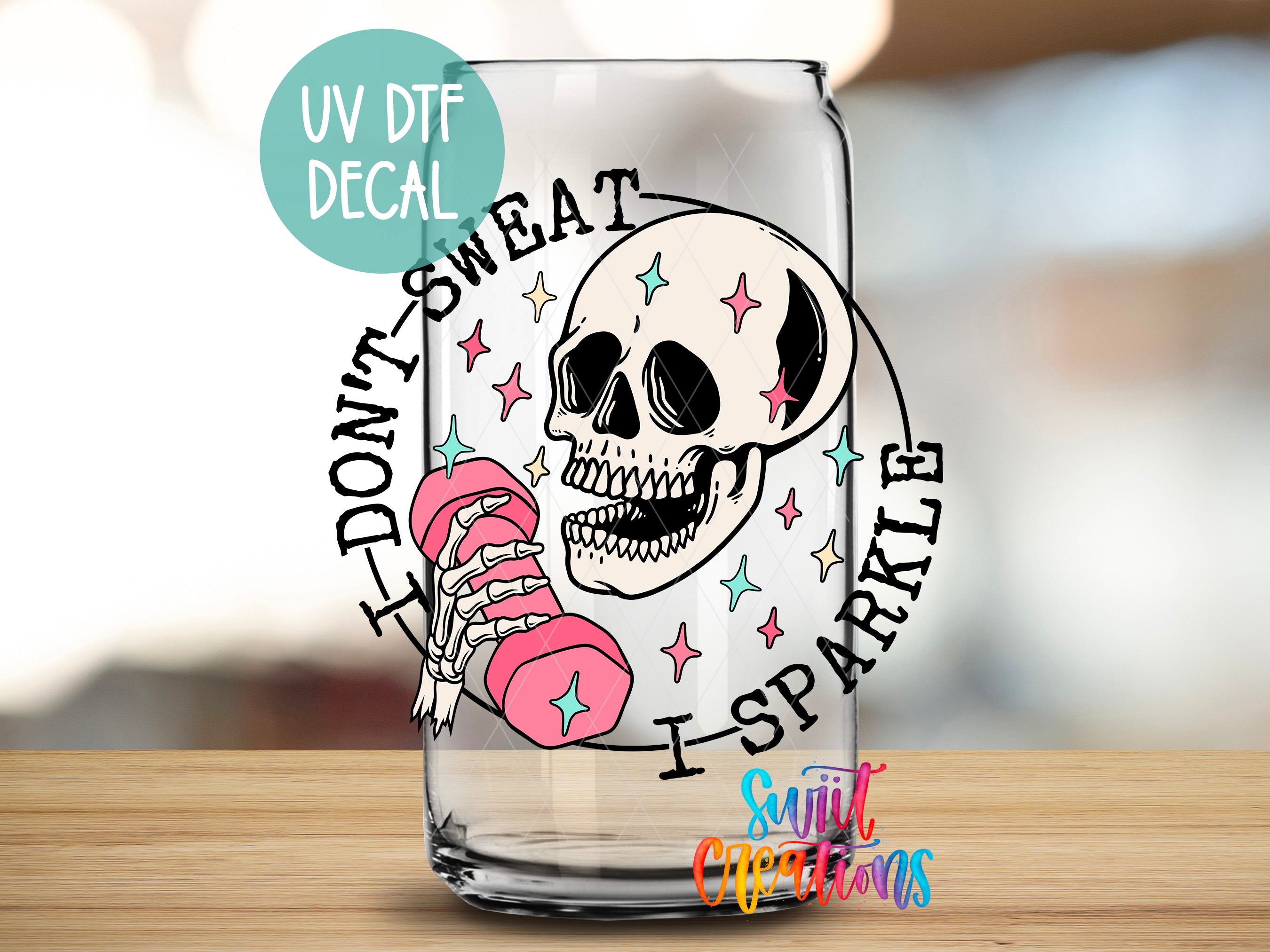 A glass with a skull and a pink dumbbell, along with the text "I DON'T SWEAT I SPARKLE" and "UV DTF DECAL".