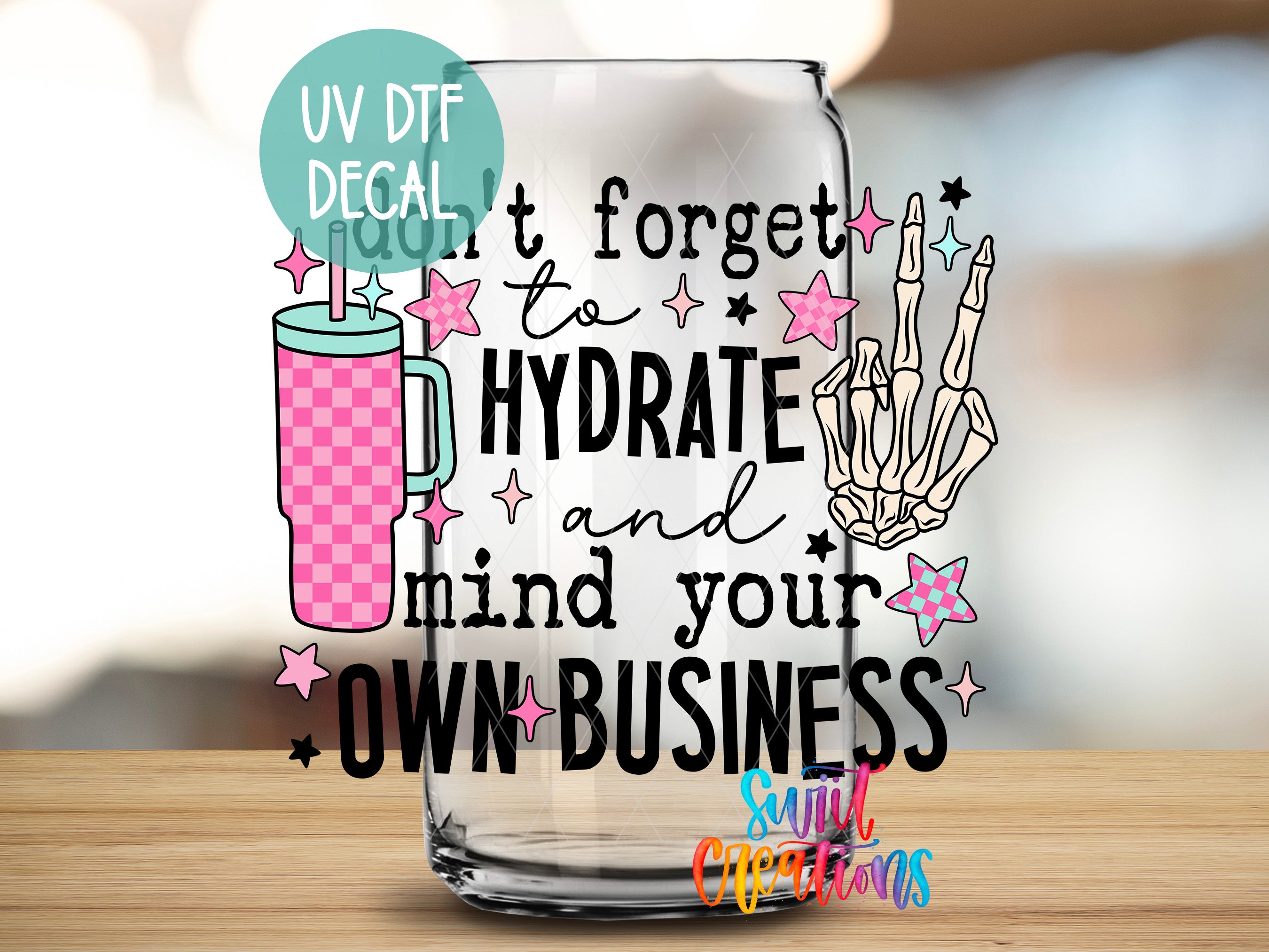 a glass with a message about hydration and business, along with various decorative elements such as stars and a skeleton hand.