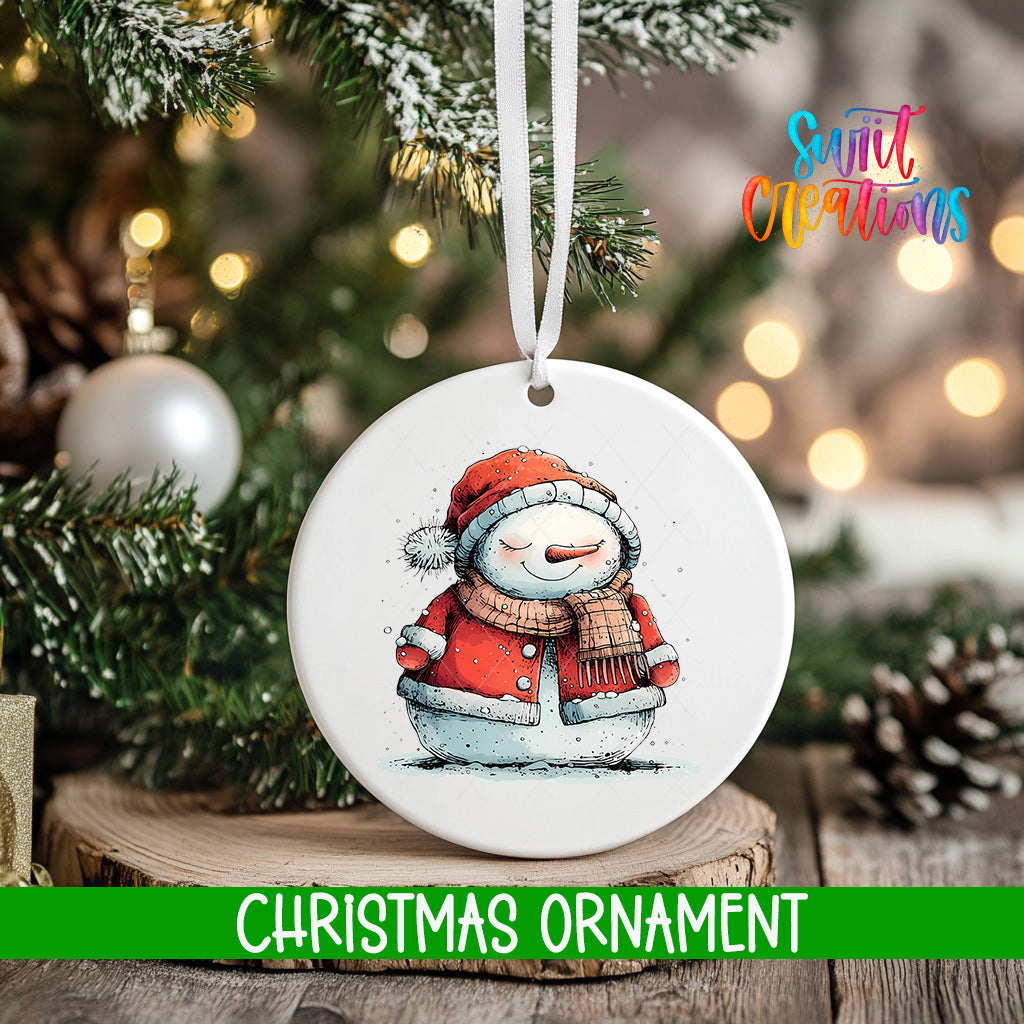 A white Christmas ornament featuring a snowman is hanging from a tree branch, with a blurred background of pine branches and twinkling lights.