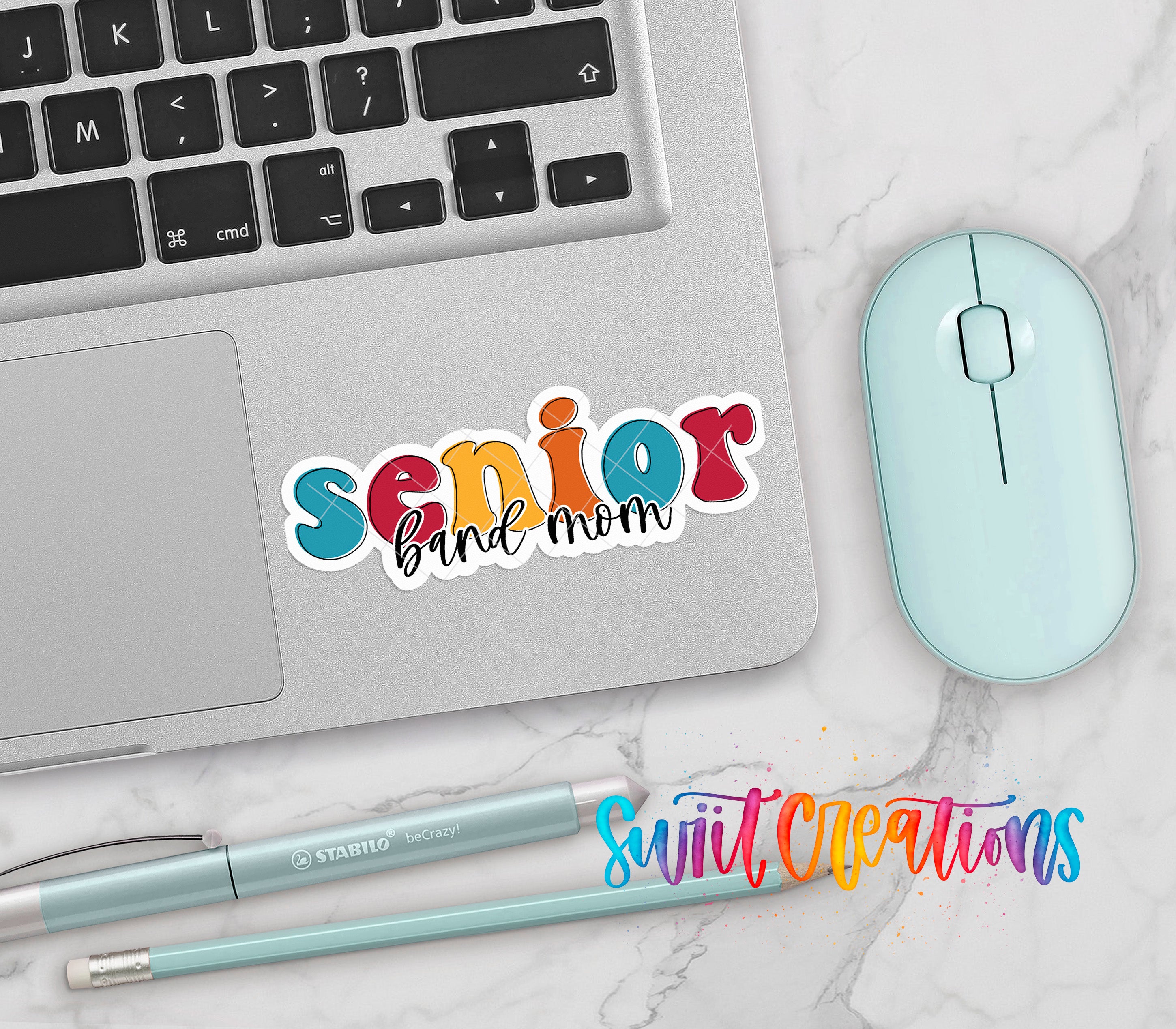 a laptop, a mouse, and some writing utensils, all placed on a marble surface.