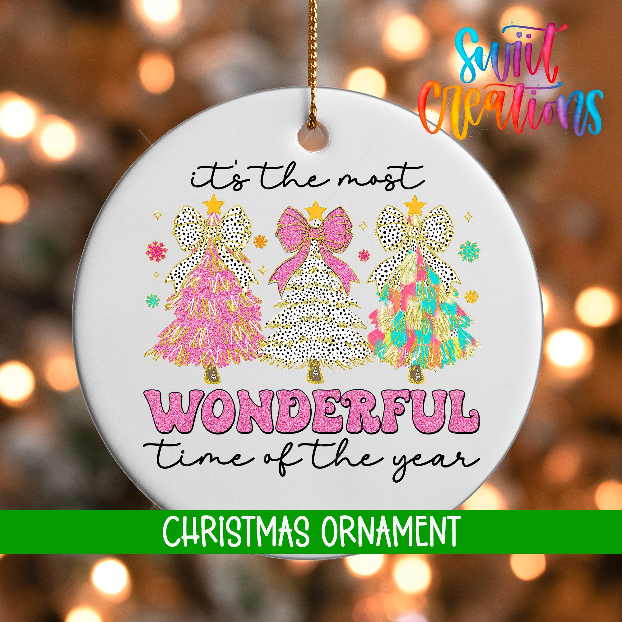 A white Christmas ornament with a festive design featuring three colorful Christmas trees and the text "It's the most wonderful time of the year" in pink and green lettering.