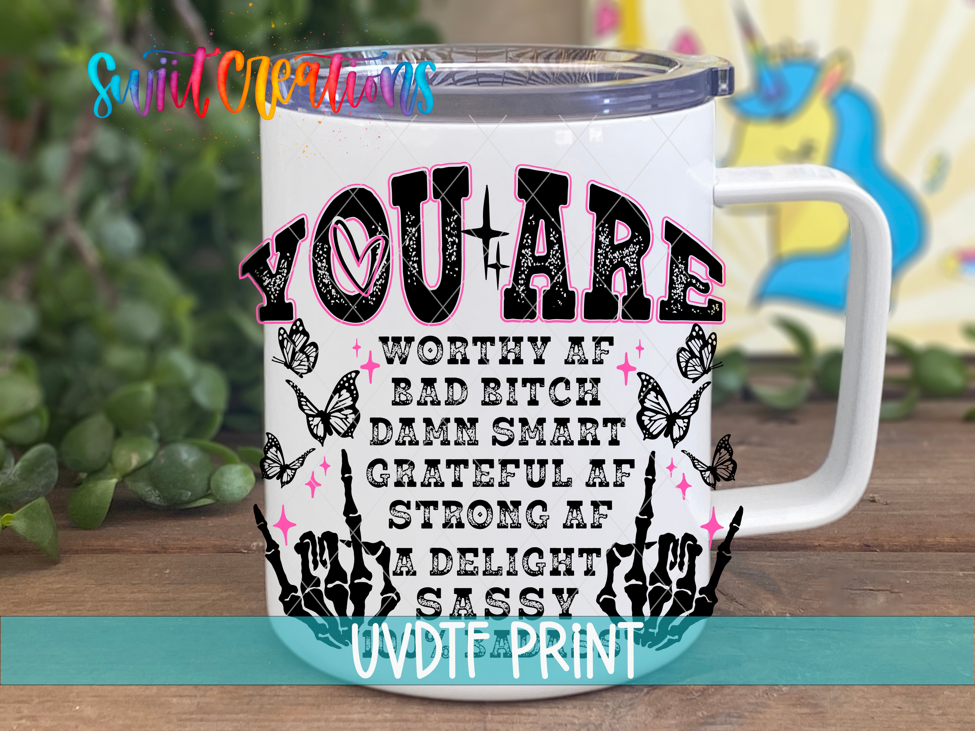 A white mug with a colorful and playful design featuring text and illustrations.