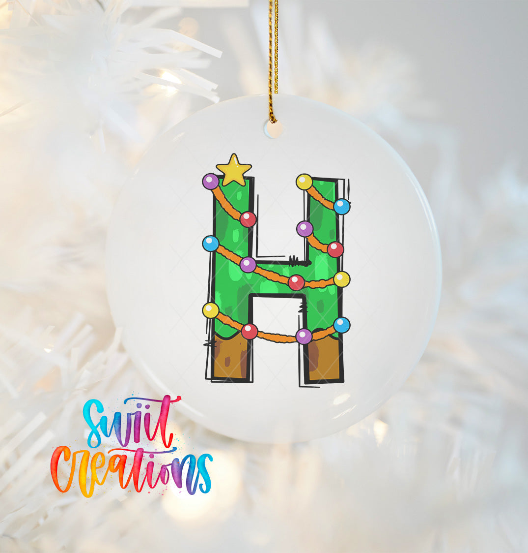 A white ornament with a colorful design of a letter "H" hanging on a Christmas tree.