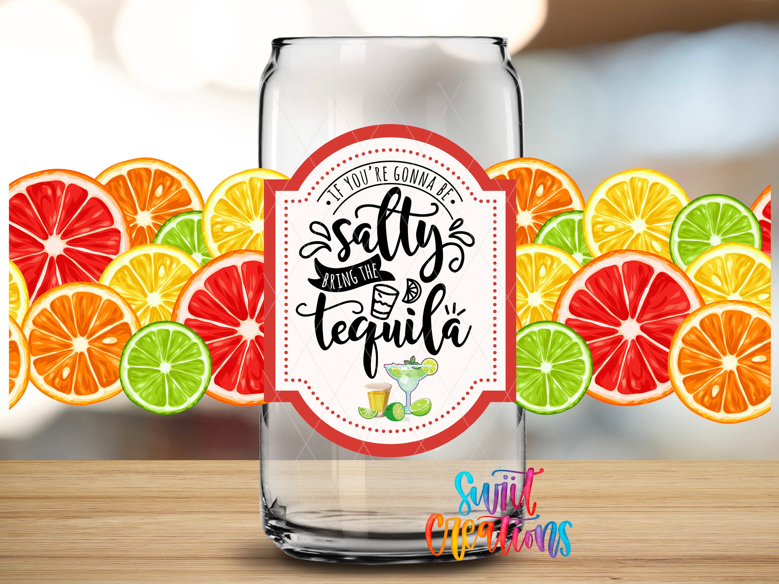 A clear glass can with a label that says "If you're gonna be salty, bring the tequila" surrounded by slices of various citrus fruits.